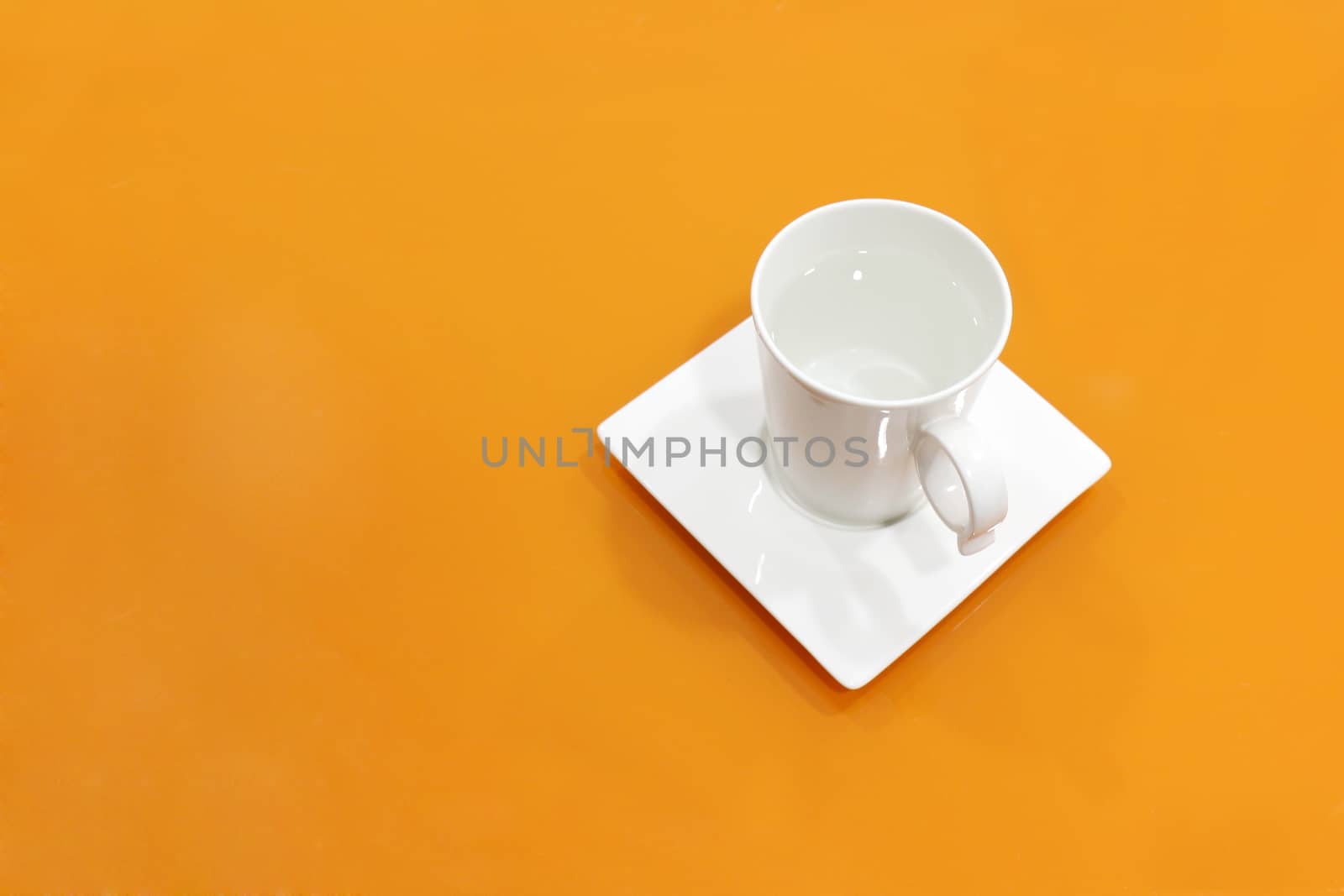 coffee cup white on top table orange, water mug white on background orange