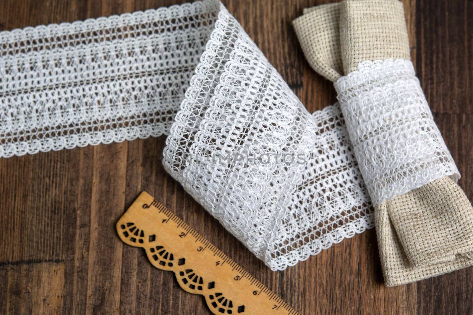 knitted white openwork linen ribbon tapes in rural style of rustics cotton eco natural on wood ground