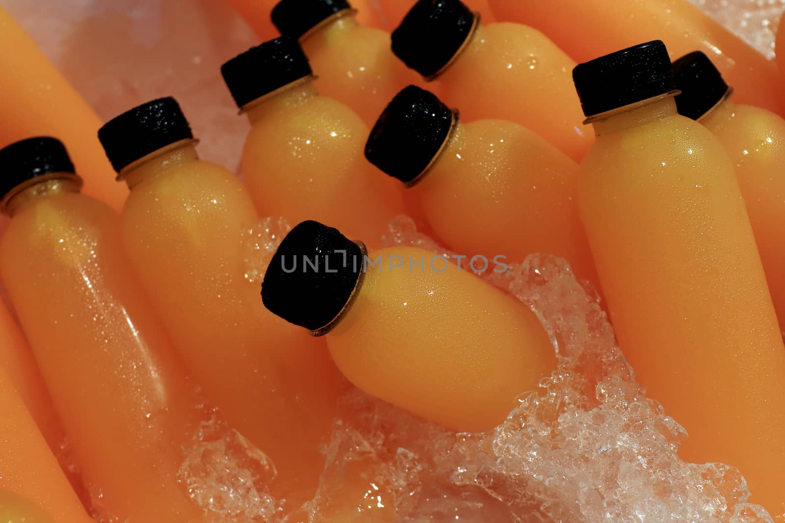 Orange Juice fresh in bottle ice cooler at market street food (Selective Focus)