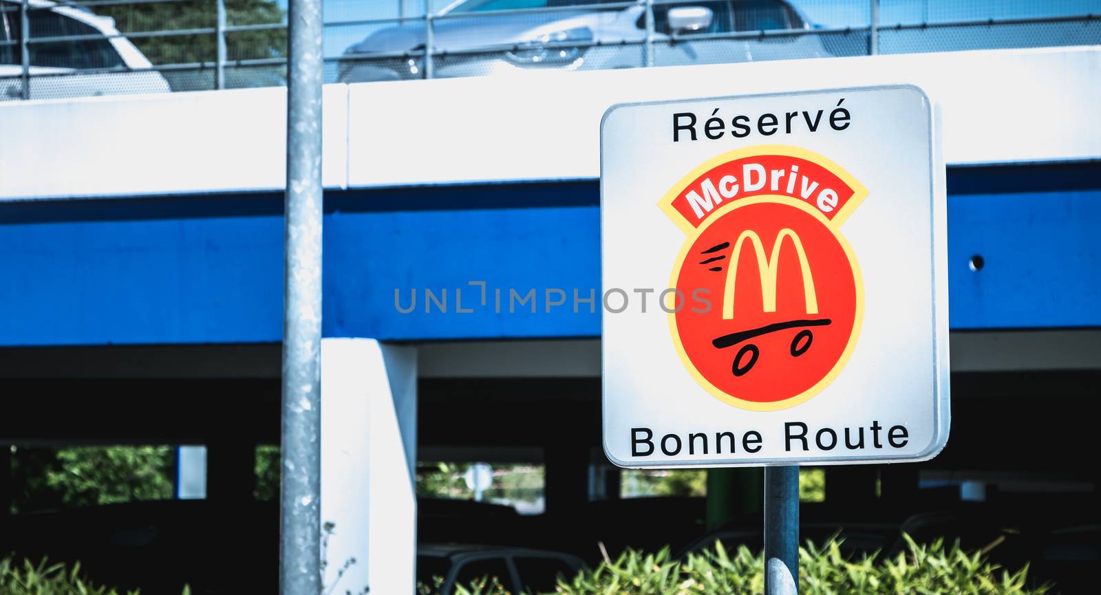 Libourne, France - May 26, 2017: Road sign indicating a place reserved for McDrive customers in the parking lot of a McDonald s restaurant on a spring day