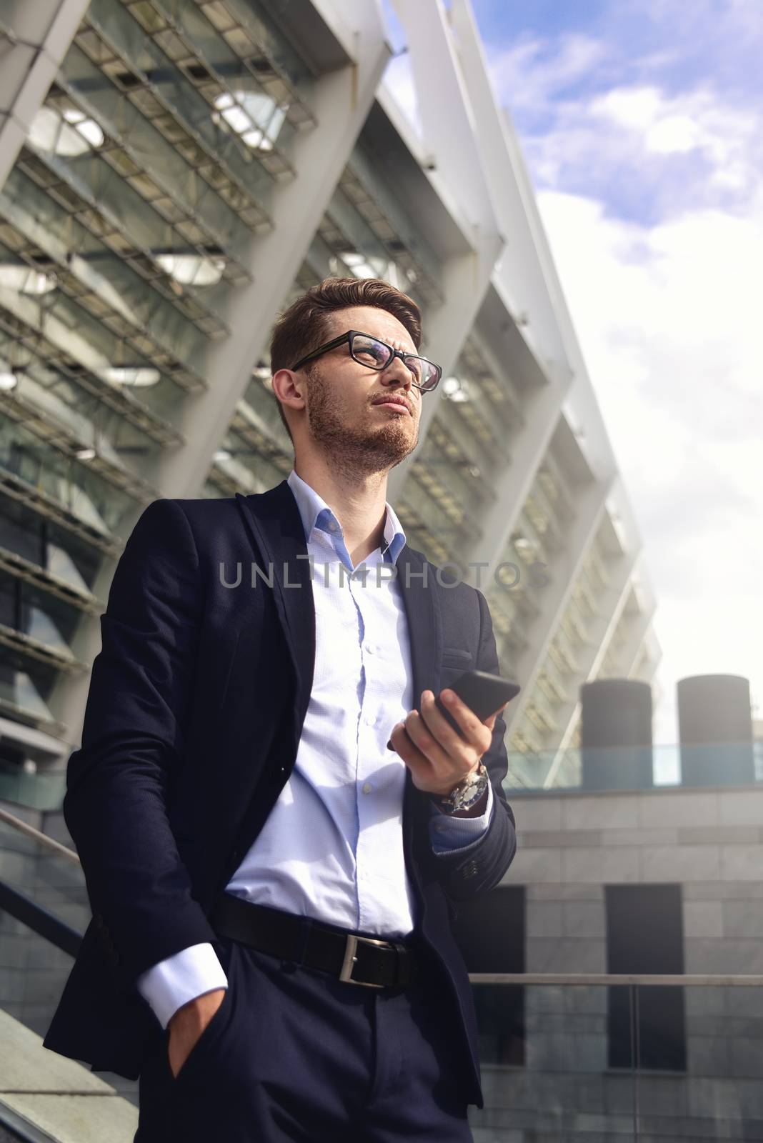 Handsome successful businessman in elegant suit outdoors walking on street in the city.