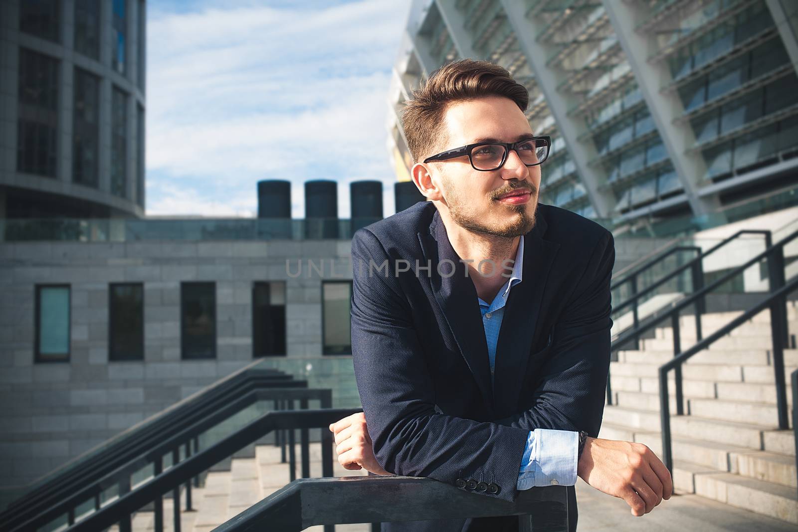 Happy businessman stand on stairs and dreaming about something.