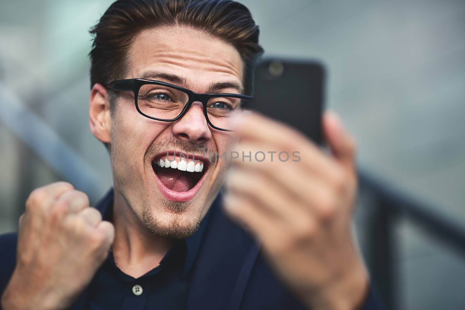 Happy caucasian businessman in glasses dressed at classic wear standing at the street.