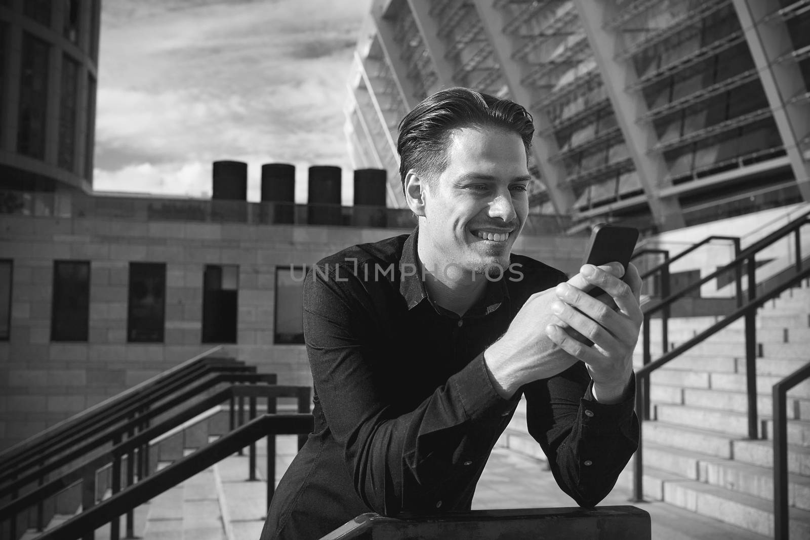 Successful caucasian businessman with smartphone stand at street in the city.