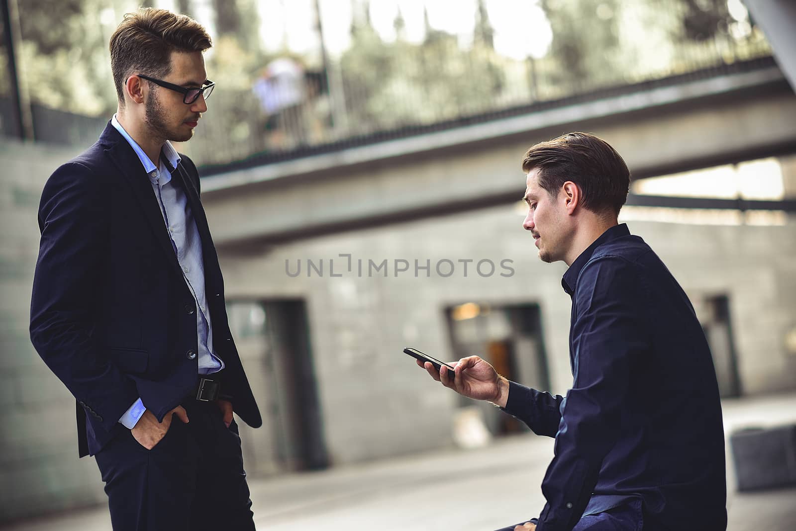 Upset young caucasian man reading a message on his mobile phone.