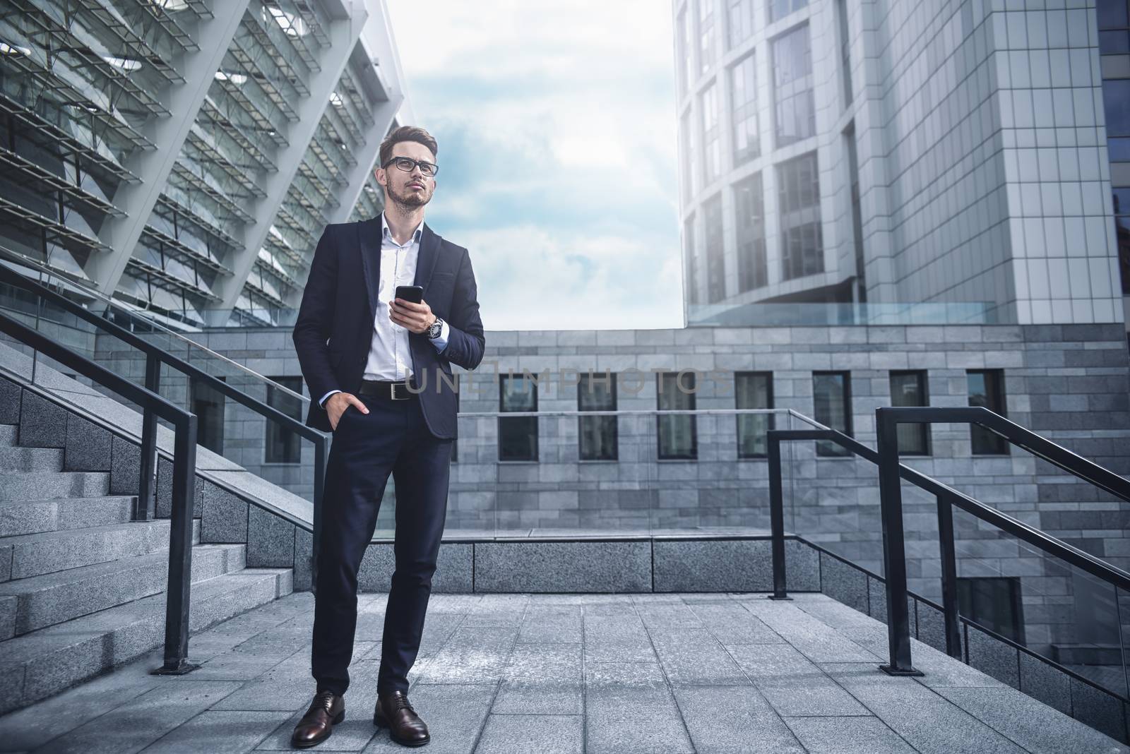 Handsome successful businessman in elegant suit outdoors walking on street in the city.