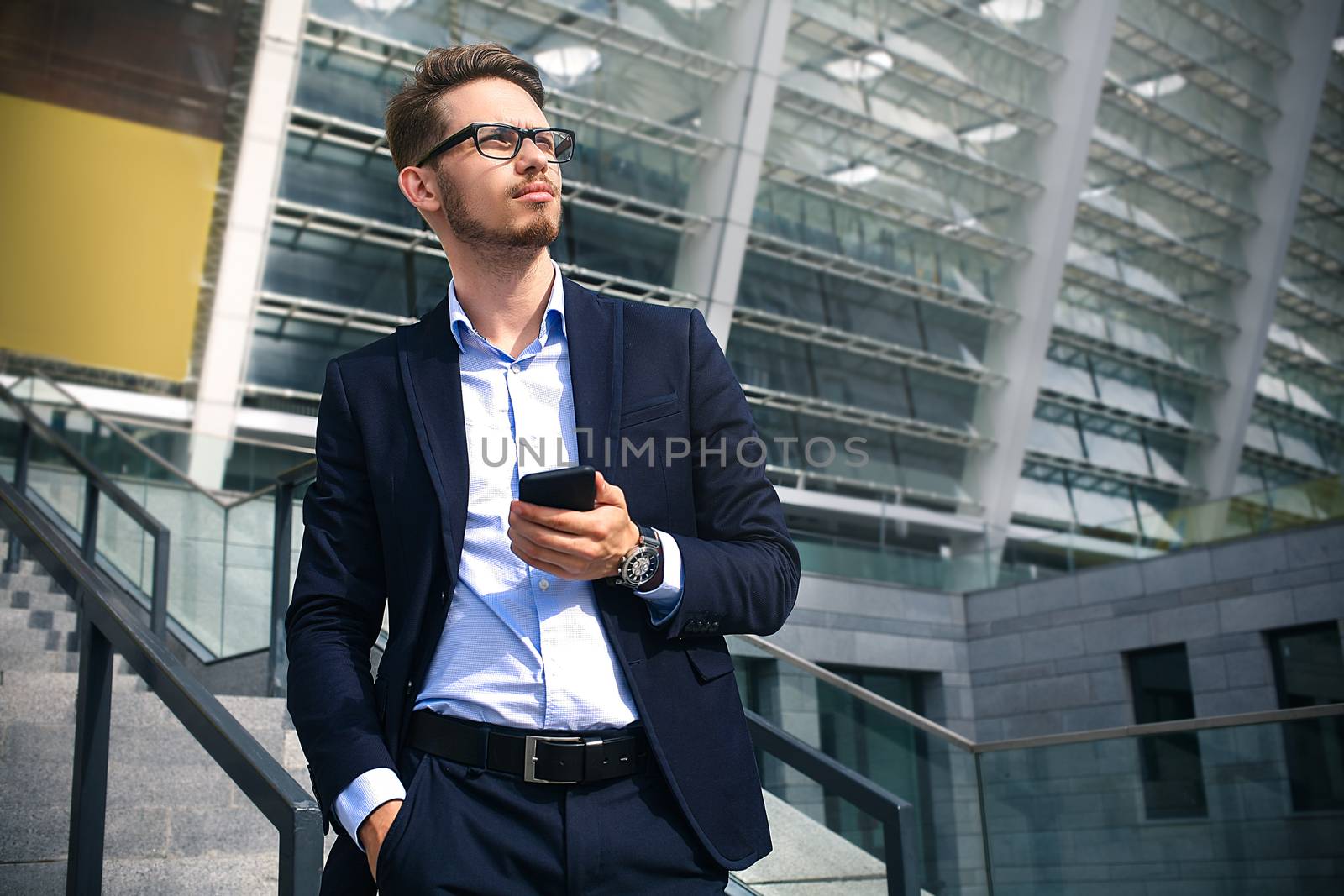 Handsome successful businessman in elegant suit outdoors walking on street in the city.