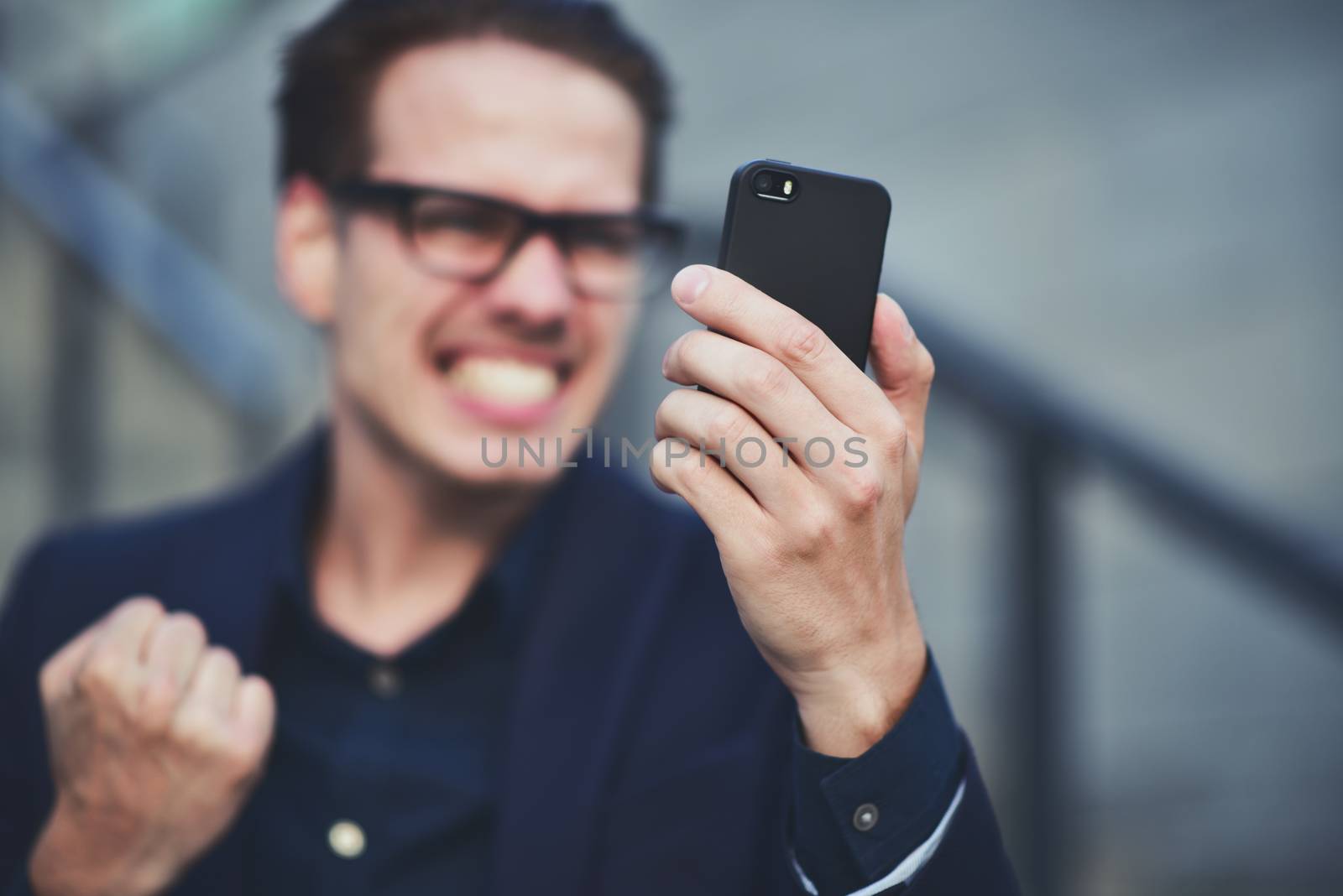 Happy caucasian businessman in glasses dressed at classic wear standing at the street.