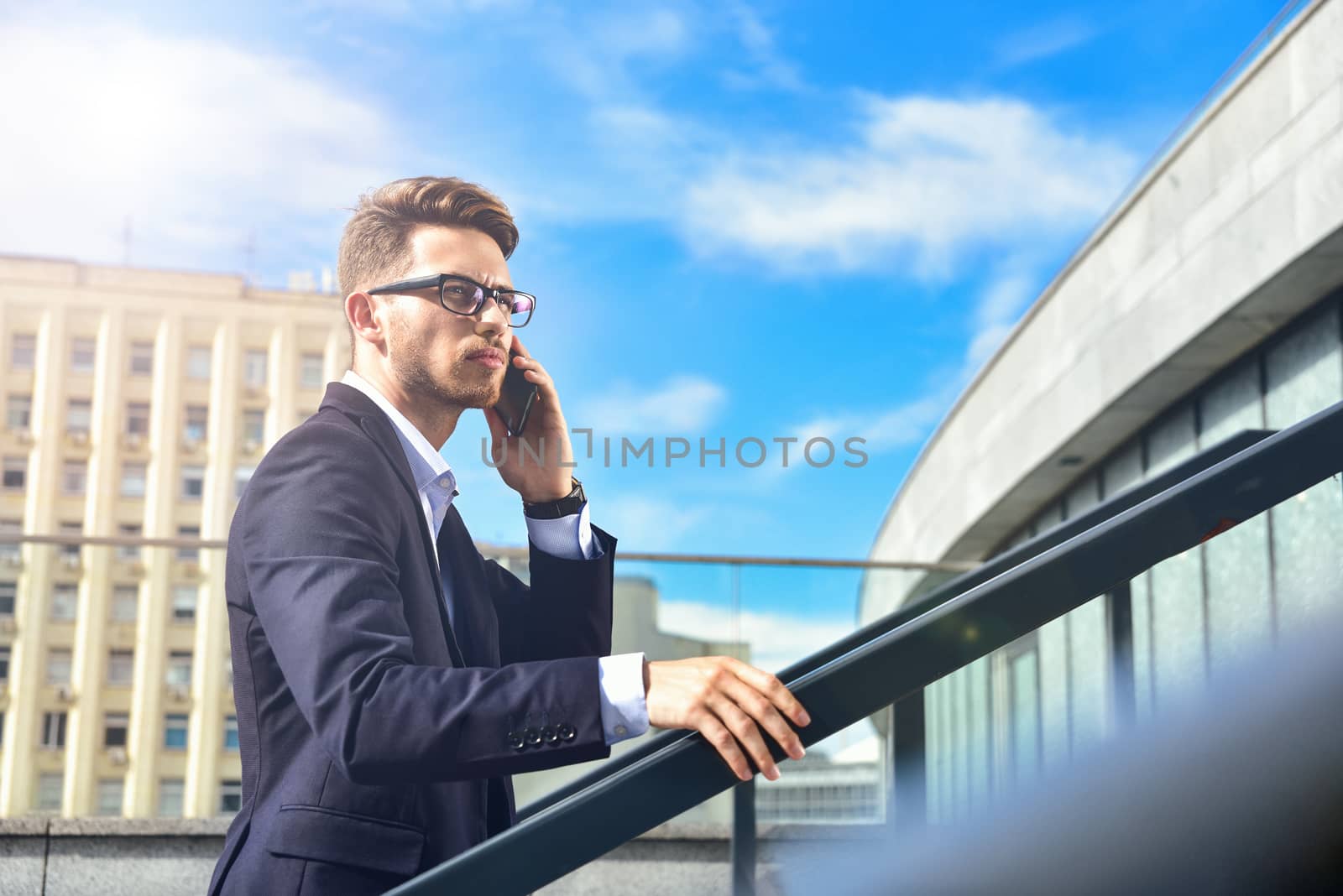 Handsome successful businessman in elegant suit outdoors walking on street in the city.