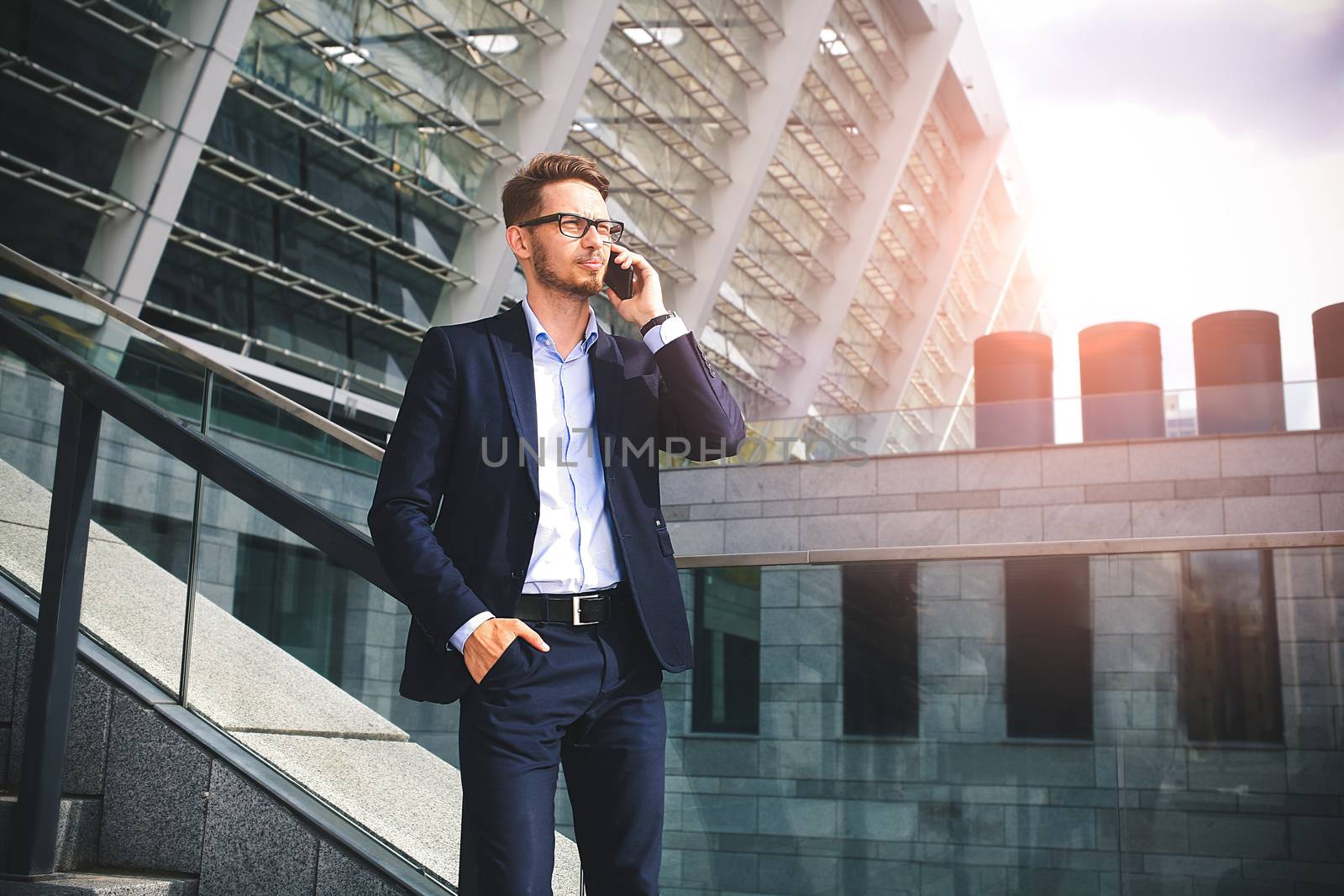 Handsome successful businessman in elegant suit outdoors walking on street in the city.
