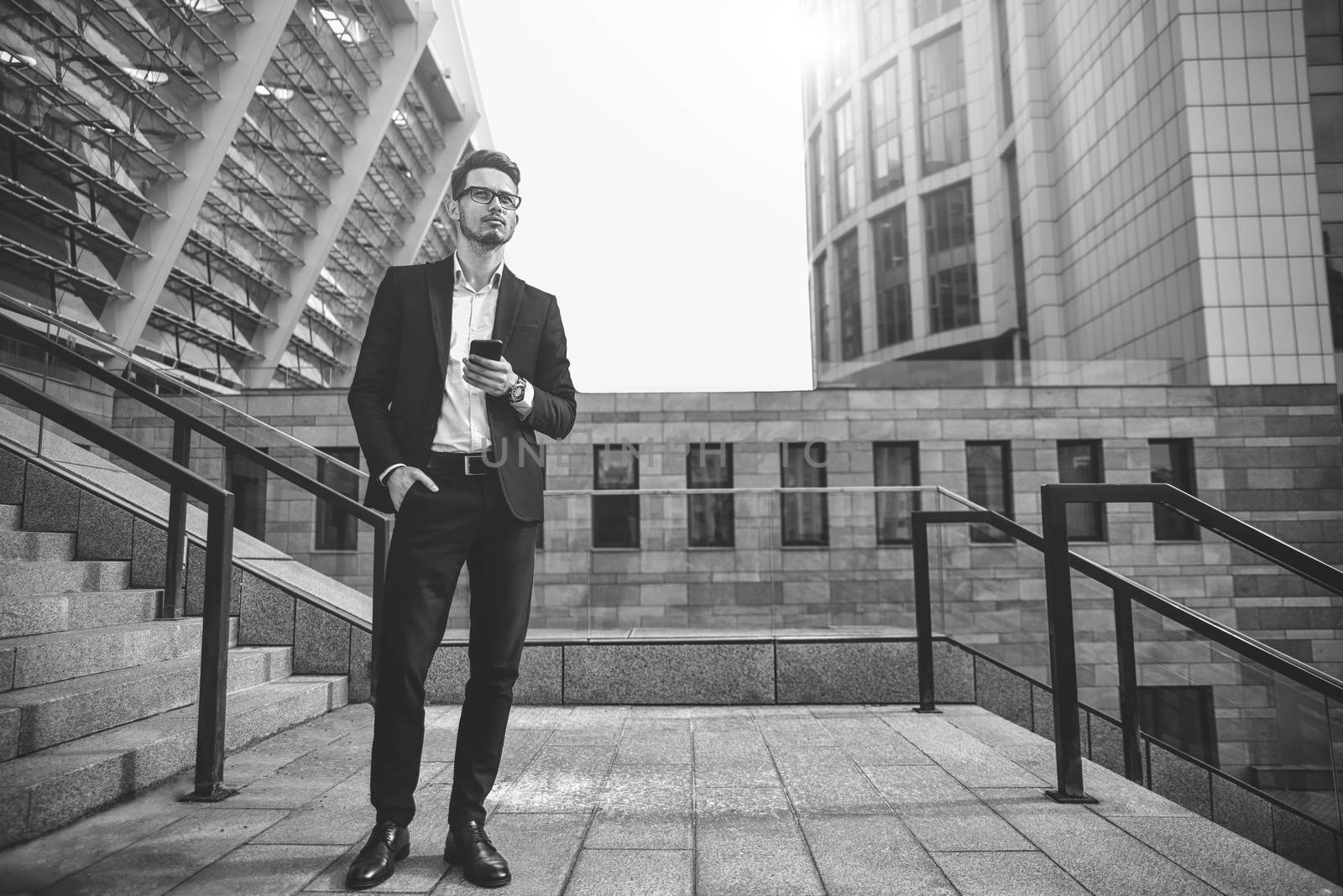 Handsome successful businessman in elegant suit outdoors walking on street in the city.