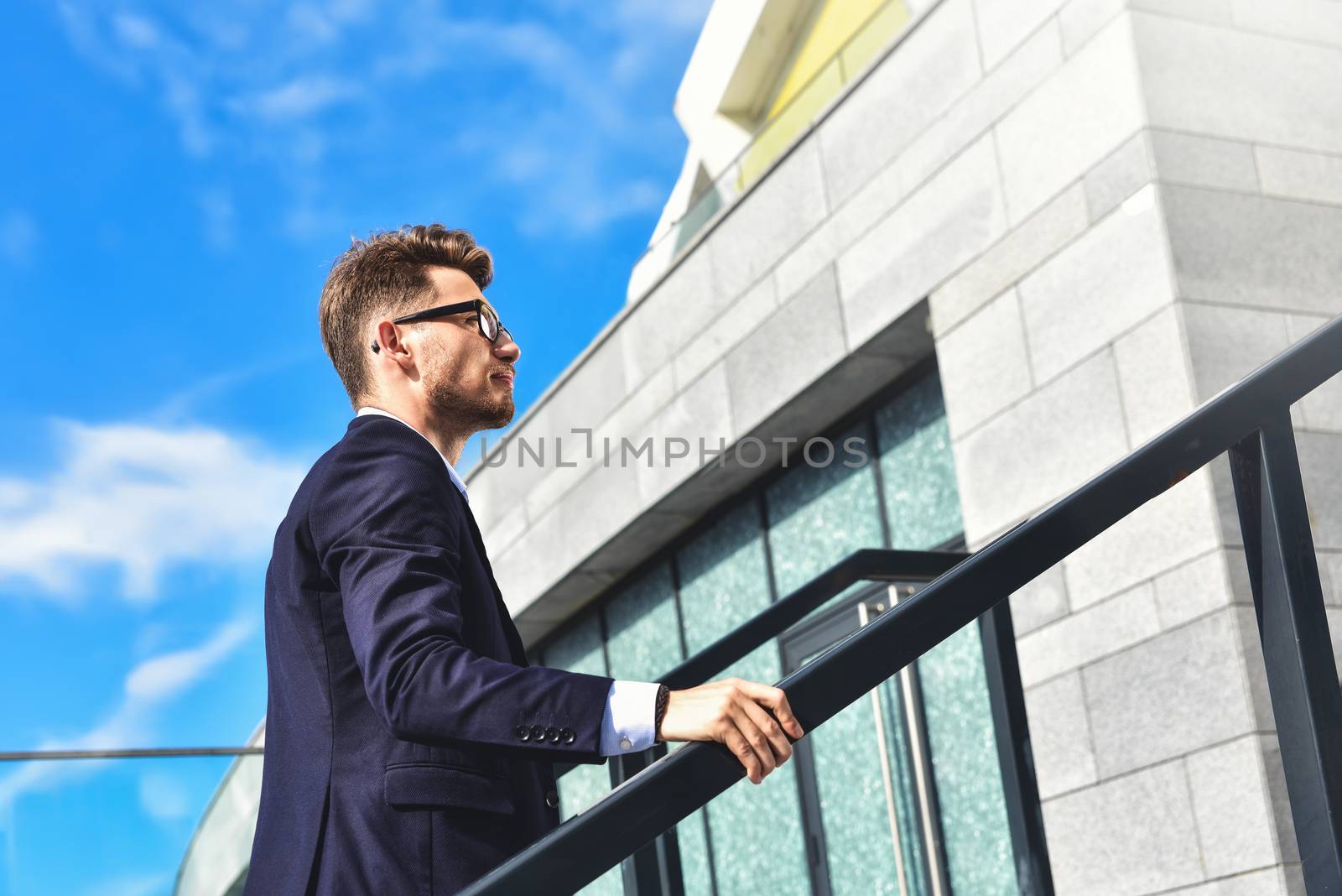 Handsome successful businessman in elegant suit outdoors walking on street in the city.