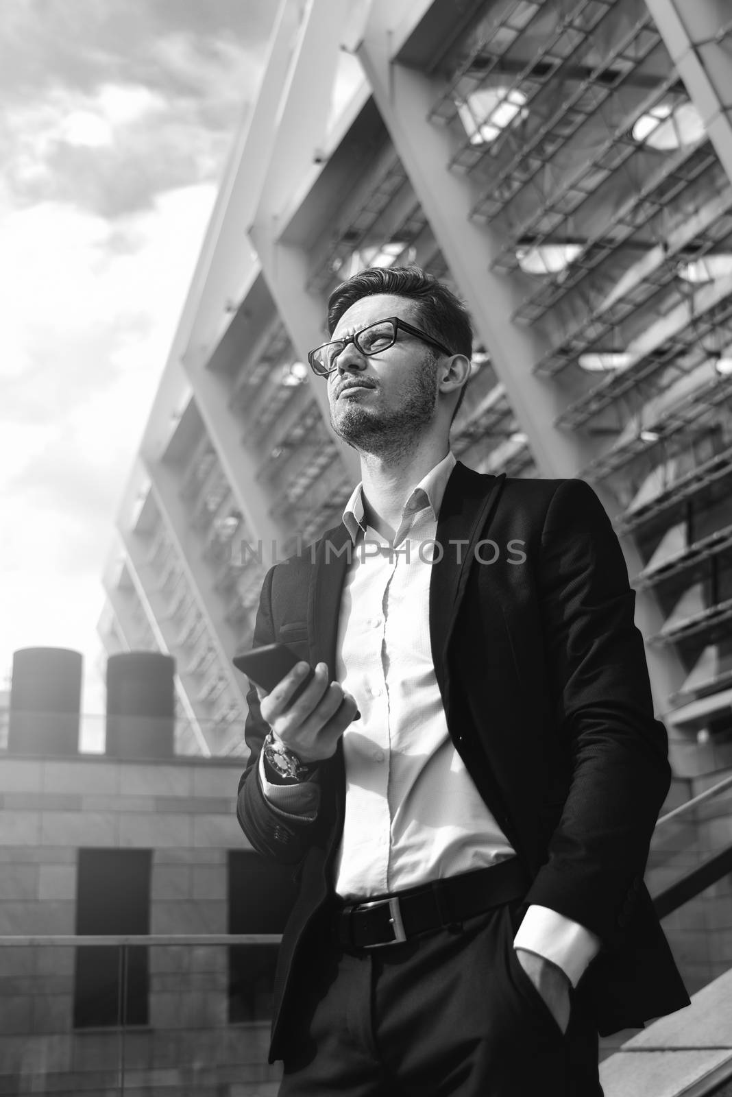Handsome successful businessman in elegant suit outdoors walking on street in the city.