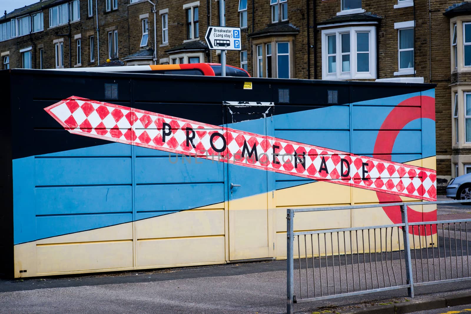 sign pointing to Morecambe promenade painted on a building by paddythegolfer