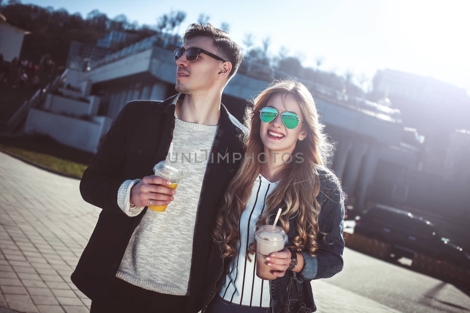 Cute couple having fun walking at the street and drink cocktails , good day