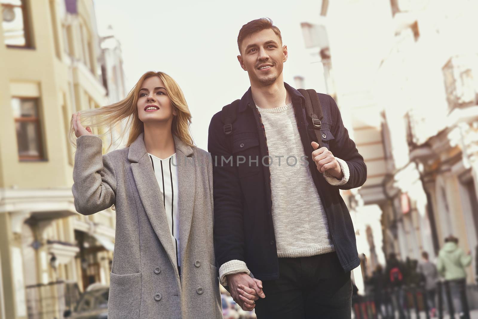 Beautiful young couple walking at street girl playing with her hair