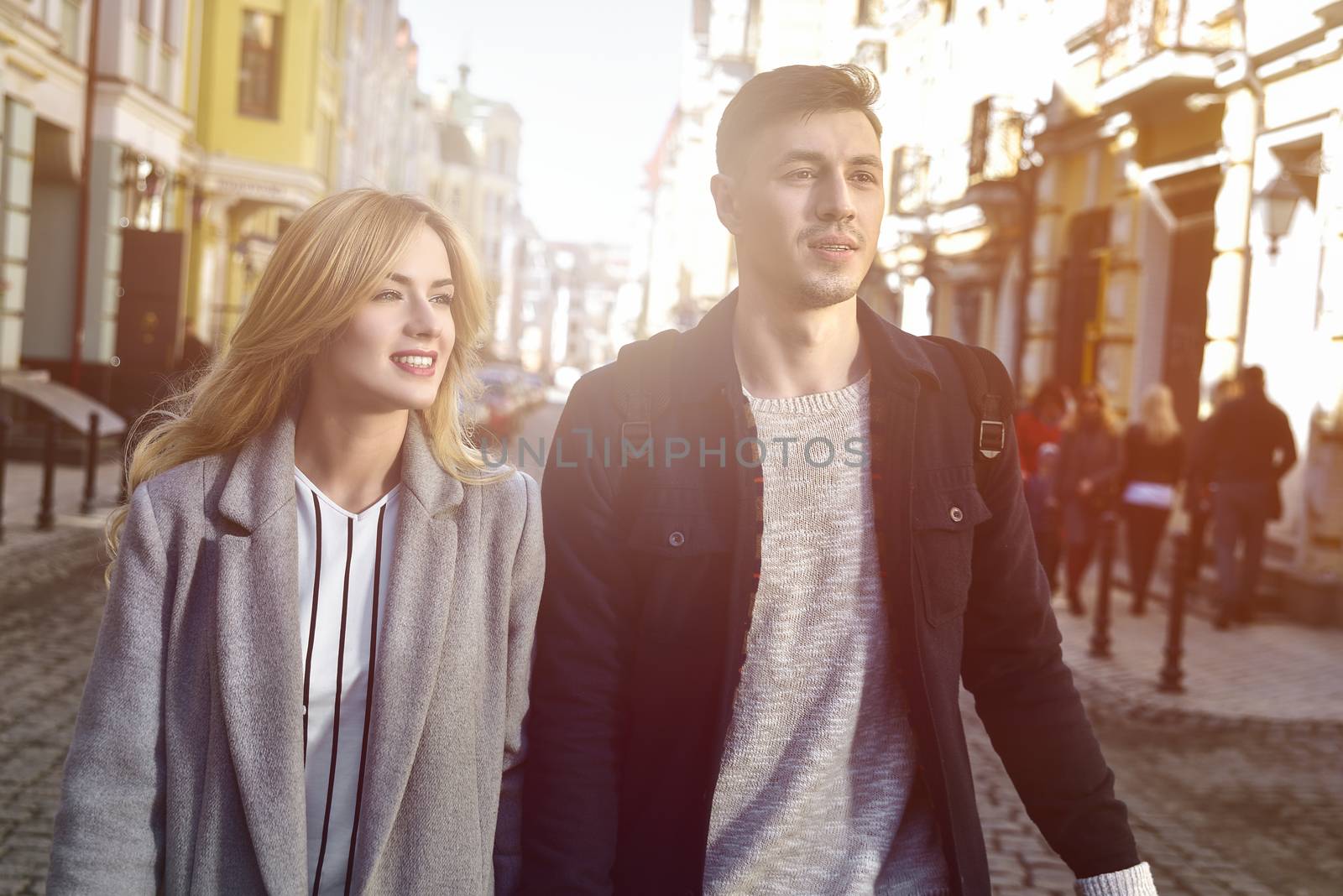 Young couple walk at the street together on sunny day