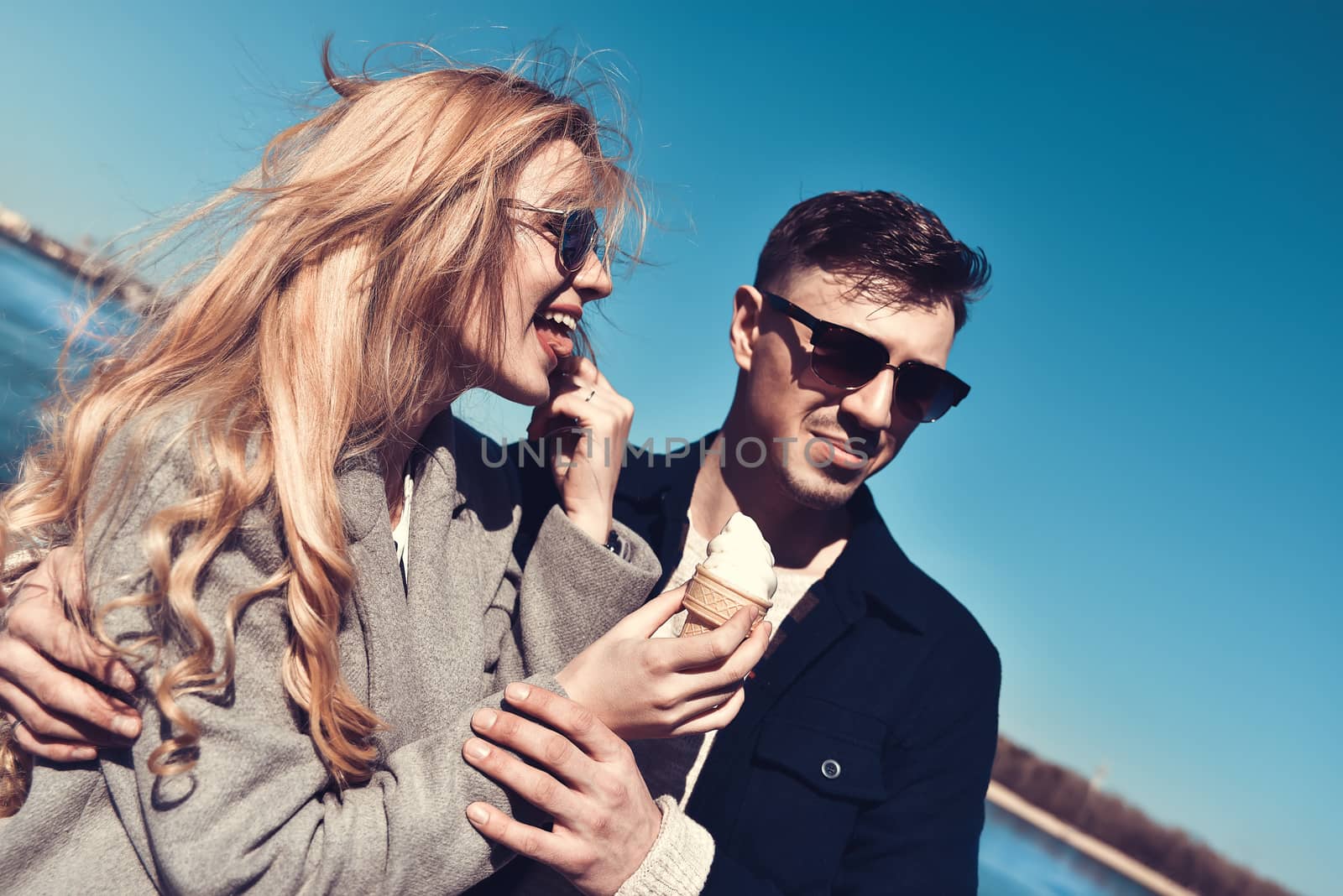 Beautiful couple stay at city embankment and eating the ice cream