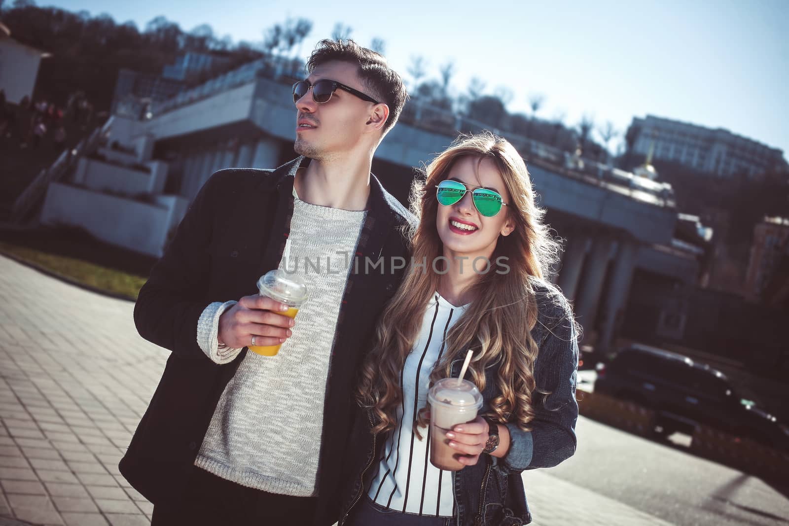 Cute couple having fun walking at the street and drink cocktails , good day