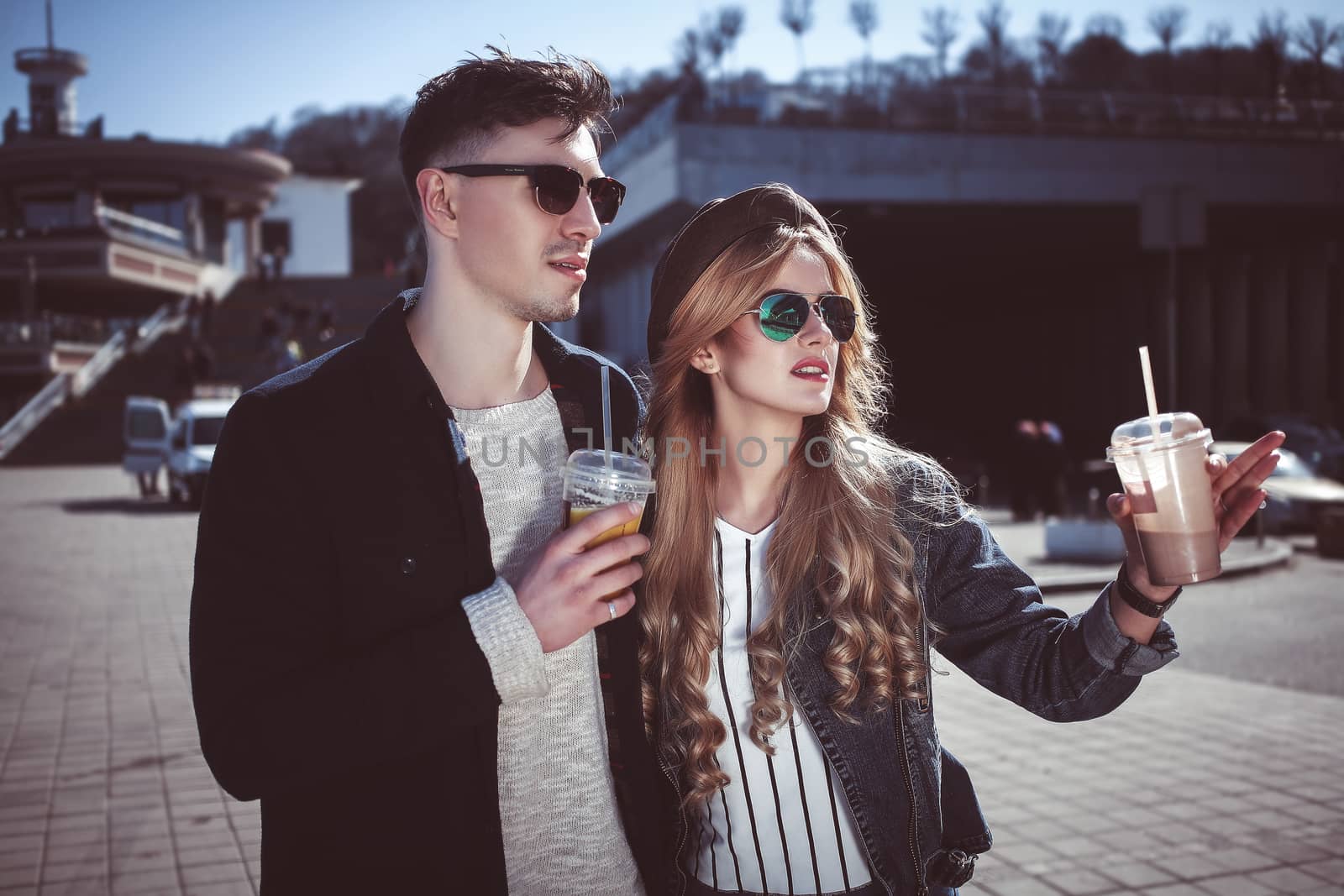 Cute couple having fun walking at the street and drink cocktails , good day