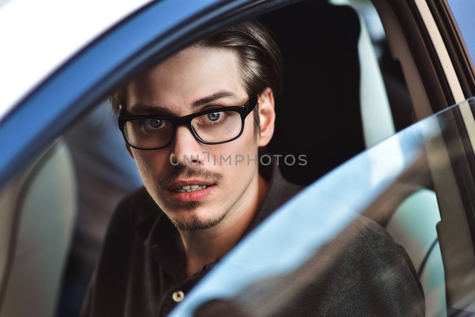 Enjoy the drive. Image of young handsome guy sitting in car.