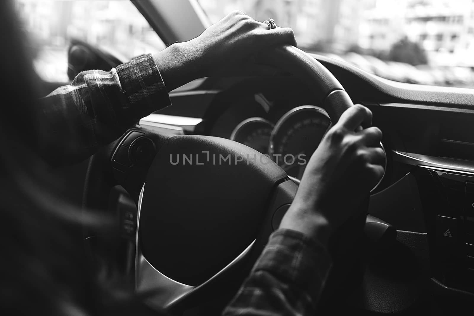 the woman in the car is driving in black and white.