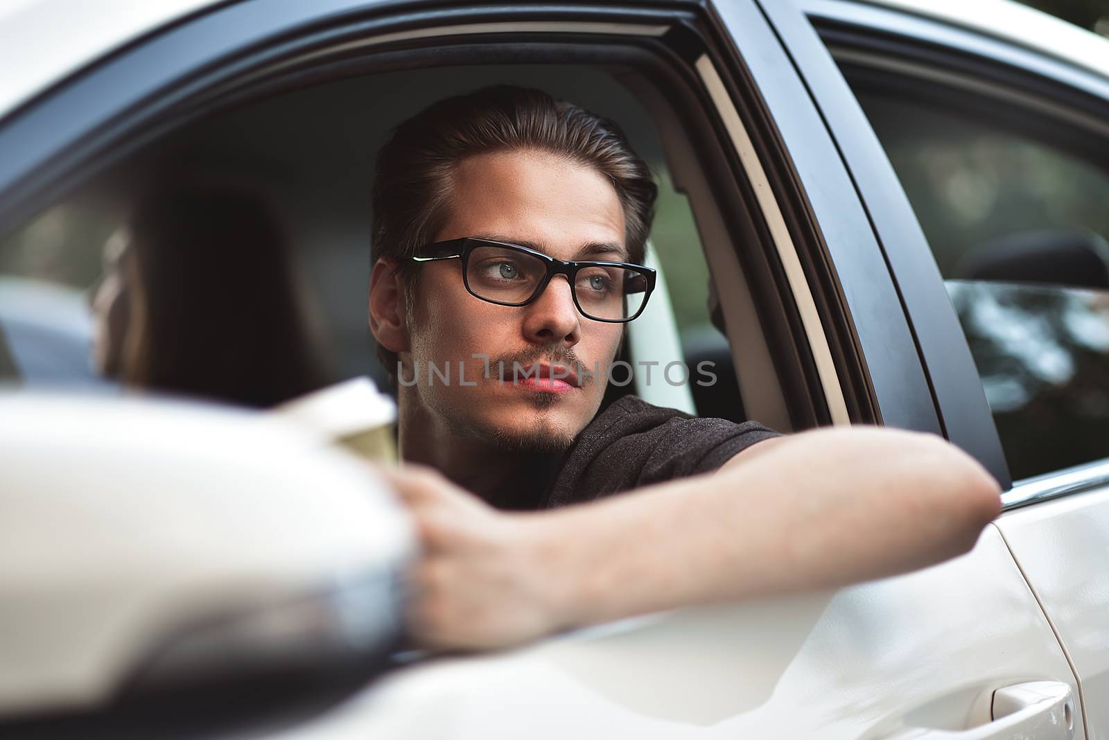 Enjoy the drive. Image of young handsome guy sitting in car.