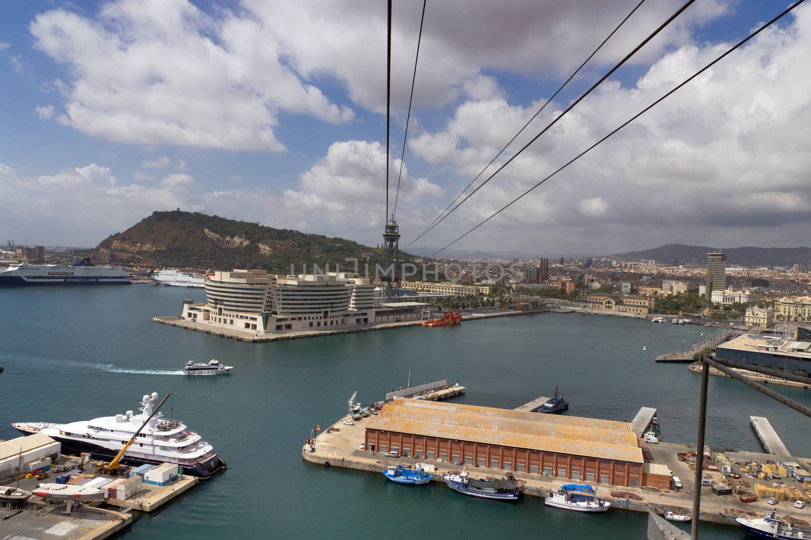 BARCELONA, SPAIN - AUGUST 27, 2012: Passenger port of barcelona and tower with a rope-way with an area of sports boats, dock and a shopping area. Catalonia, Spain.