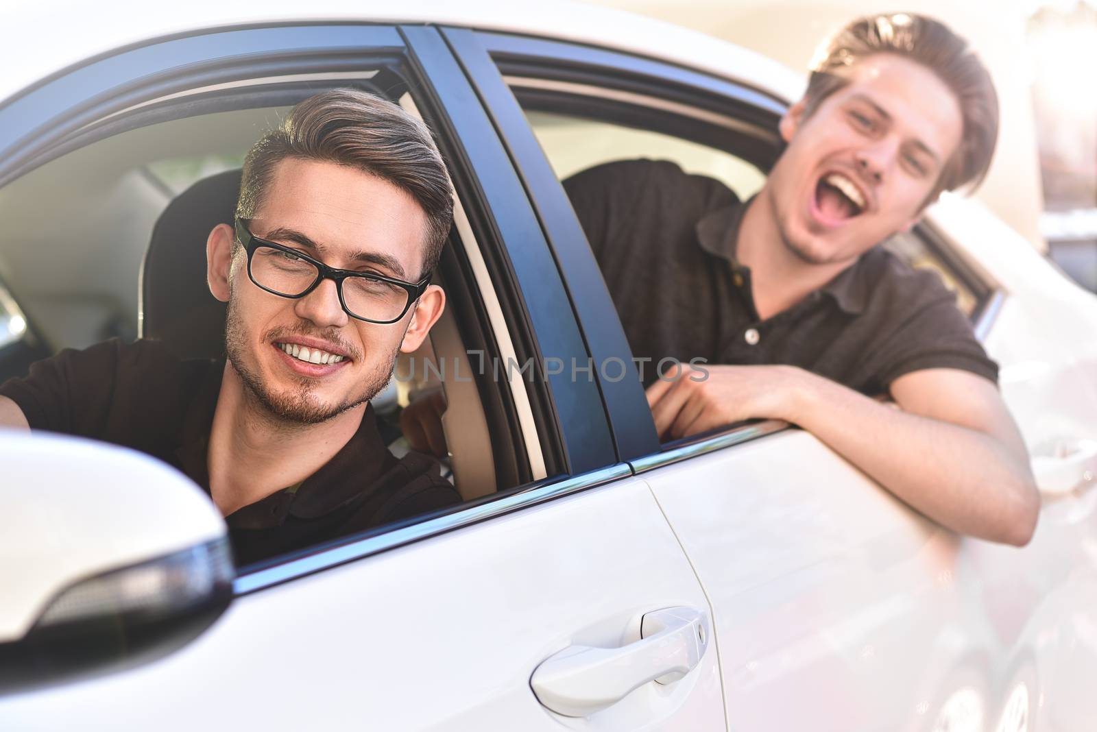 Young caucasian couple in car having fun on road trip by Nickstock