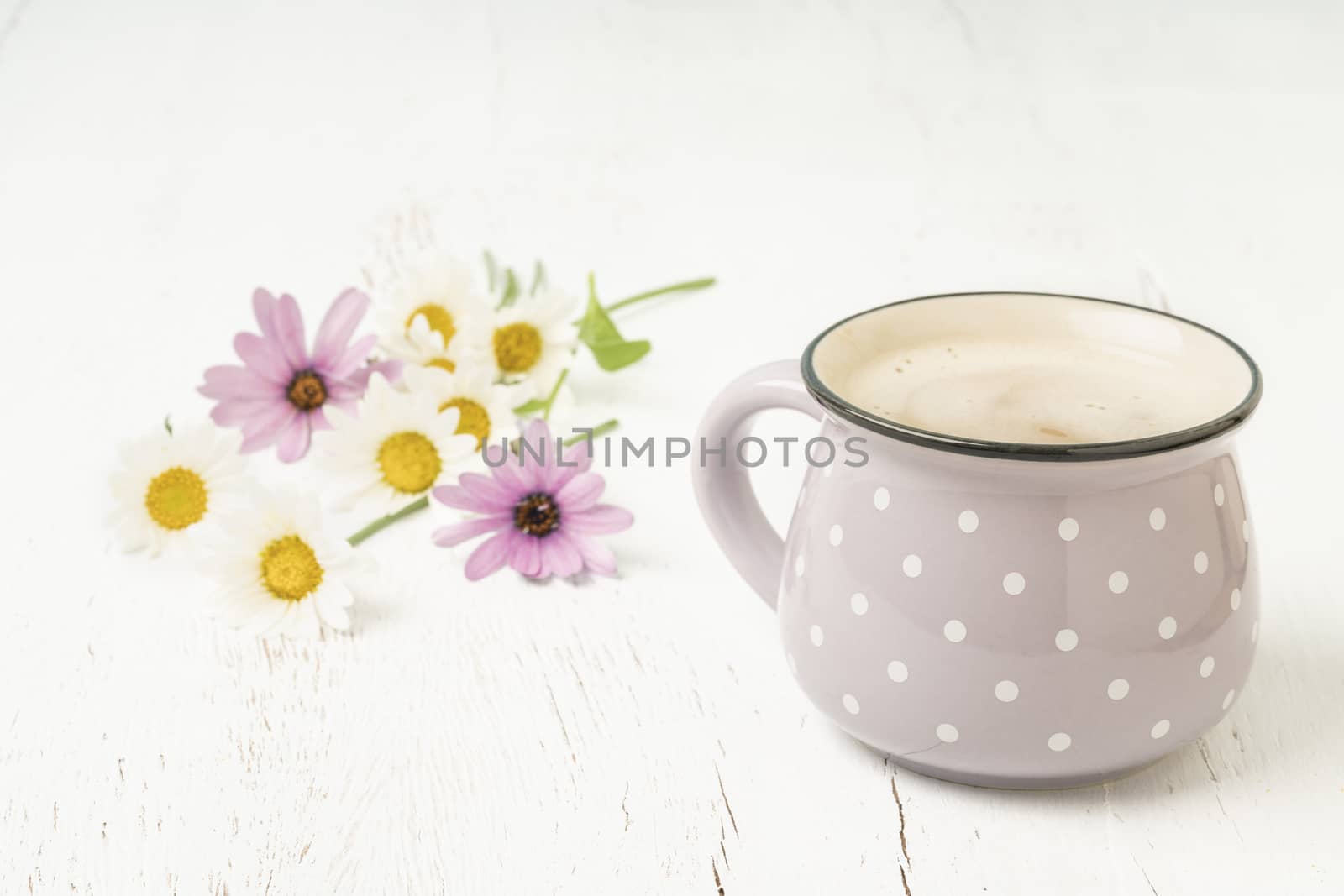 Cup of coffee on a wooden table decorated with flowers by bernanamoglu