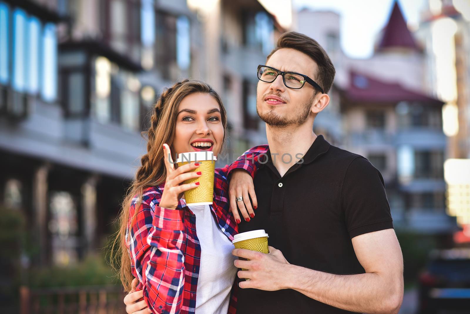 Portrait of happy couple walk on the street with coffee.