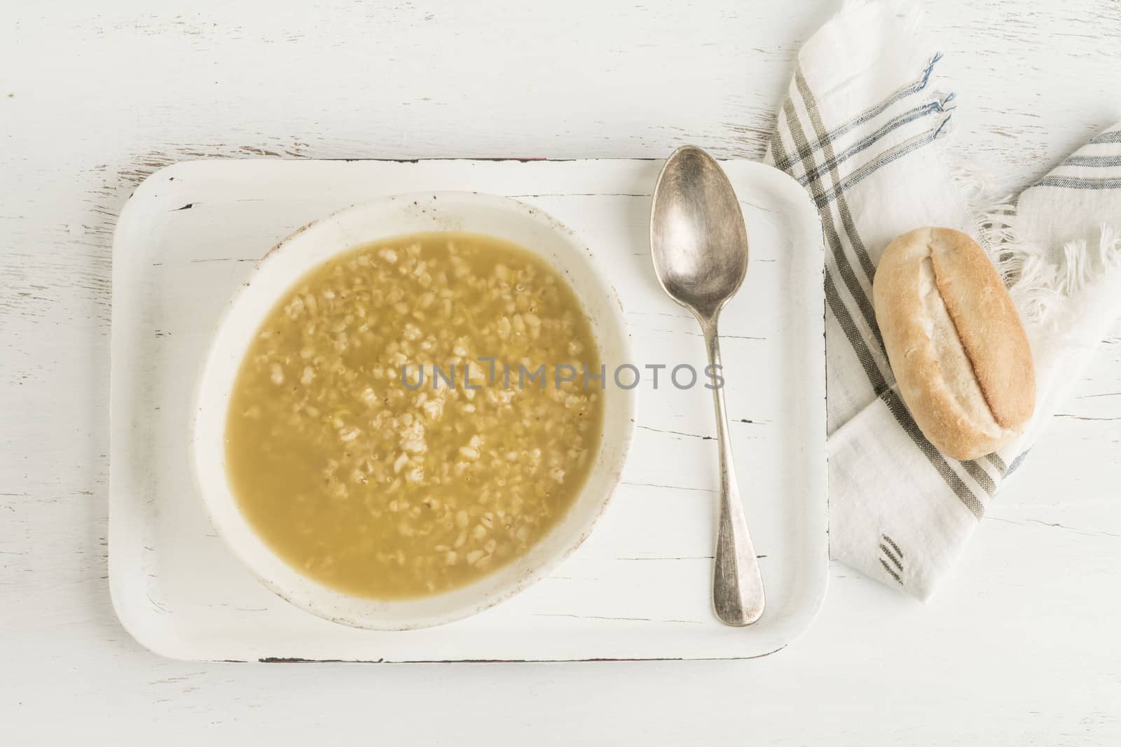 a bowl of red lentils soup and bread on a wooden table