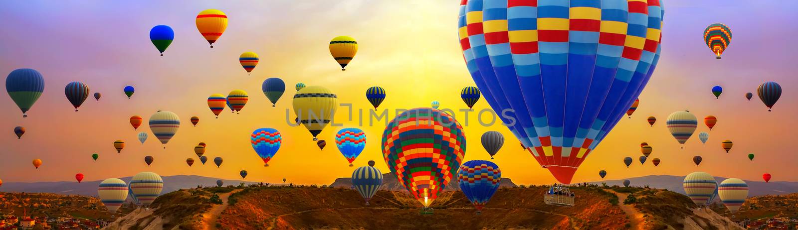 Tourists ride hot air ballons during a mass ascension at the International Balloon Festival panorama