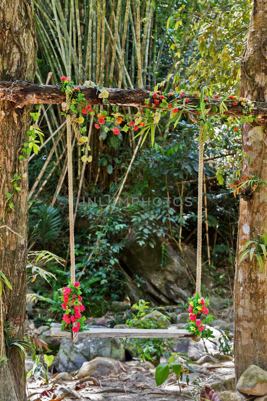 Wedding pergola seesaw lonely swing decorated with flowers at garden