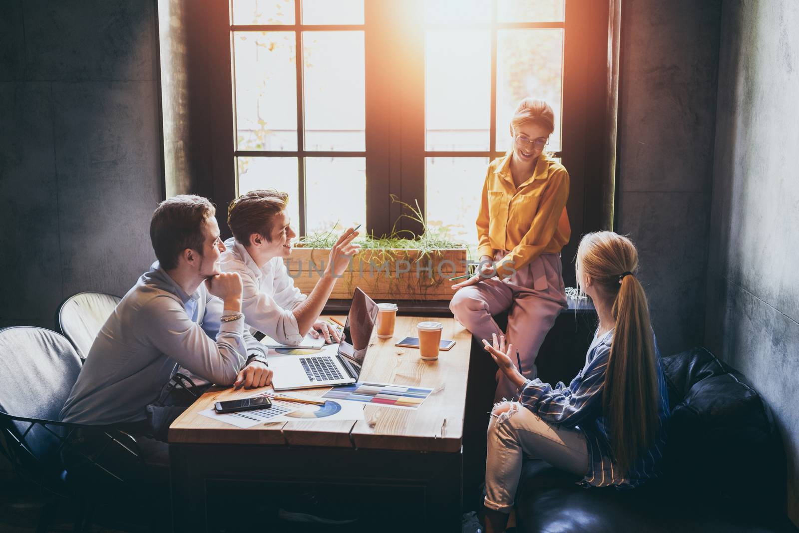 Group of colleagues having meeting in boardroom while working on big presentation and preparing their business strategy. Creative designers looking brainstorming solutions.Teamwork makes the dream work.