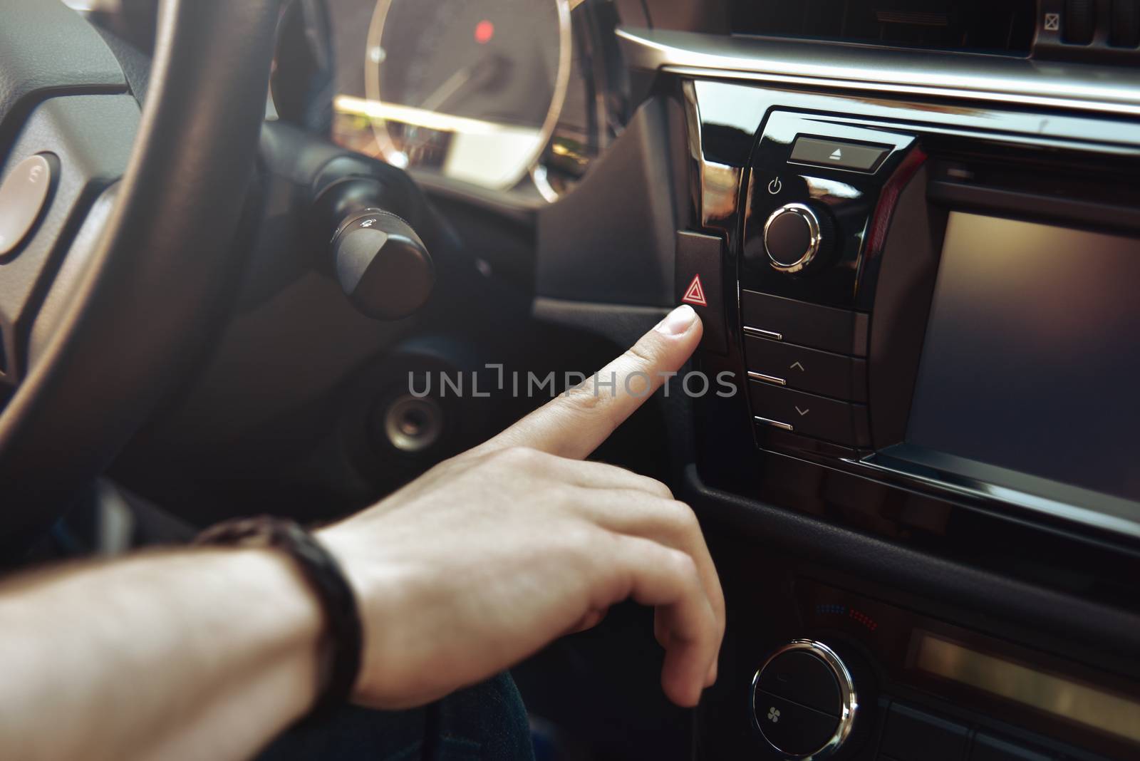 man sits in car and push on red emergency button