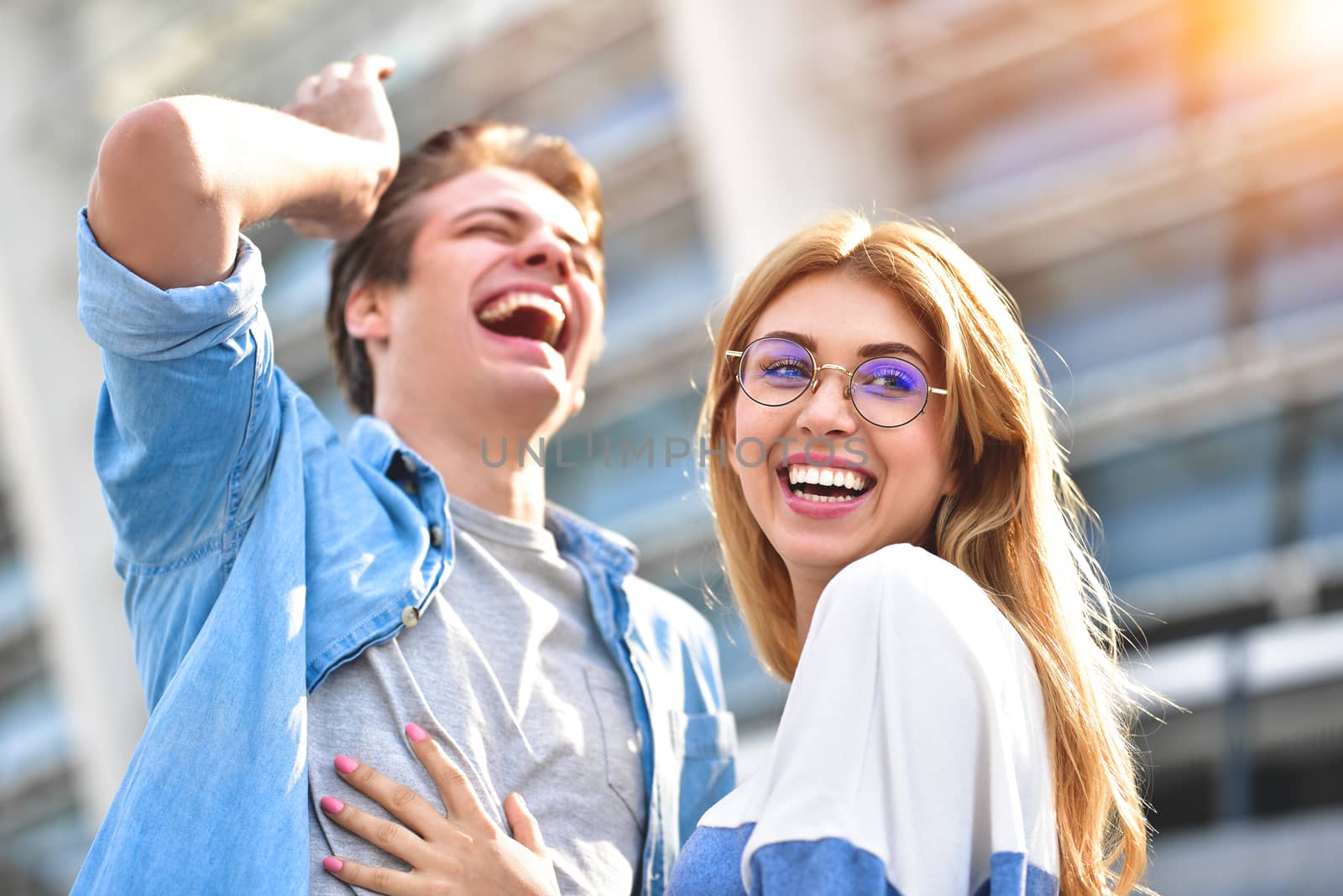 Happy to spending time together. Young beautiful couple outdoor fashion portrait. Beautiful girl tickles her boyfriend