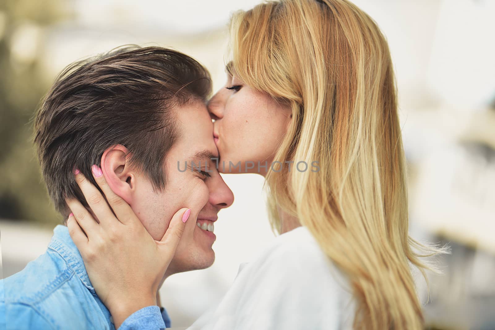 Attractive couple hugging and girl kissing a boy. by Nickstock