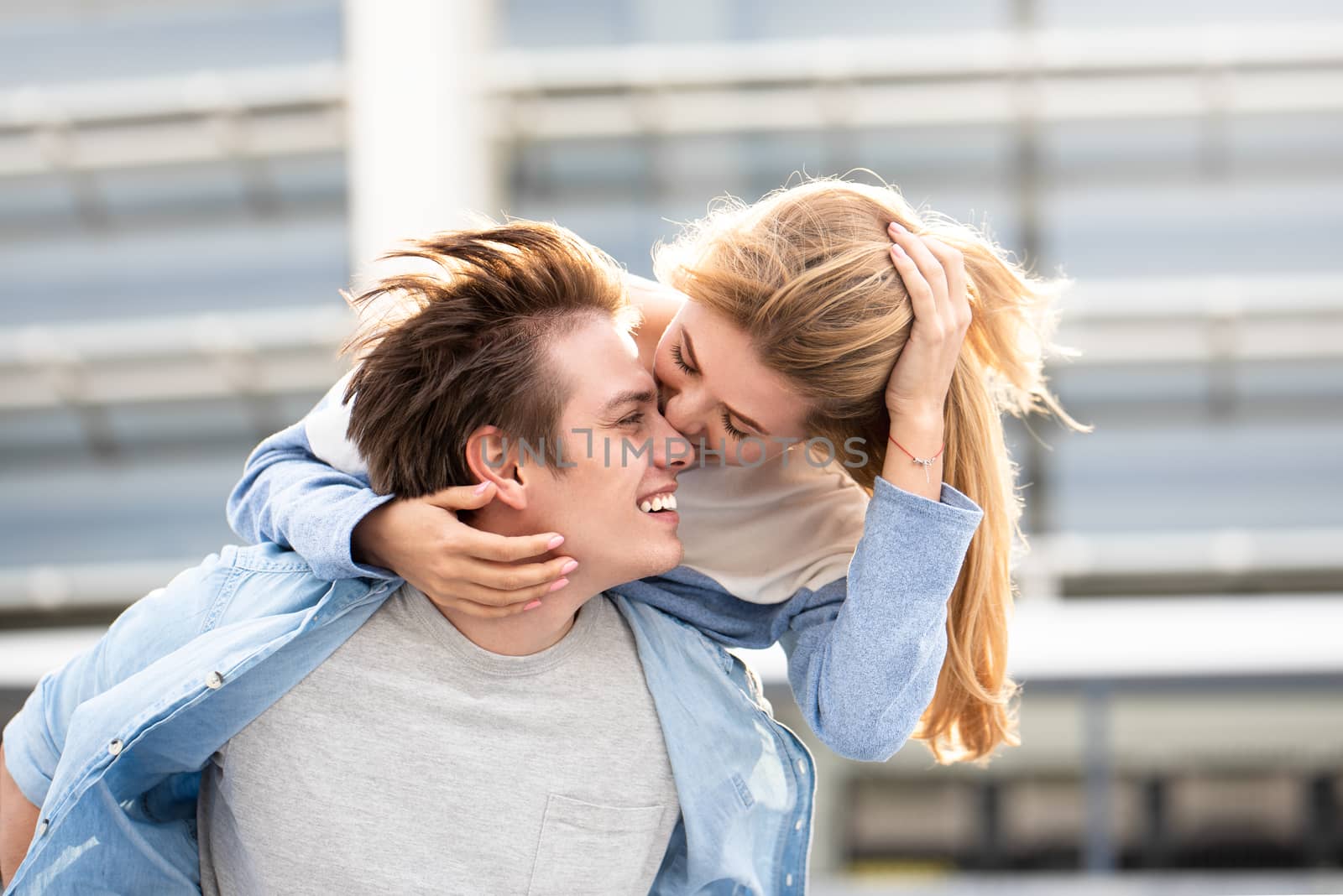 Happy to spending time together. Young beautiful couple outdoor fashion portrait. Attractive boy and girl hugging and kissing.