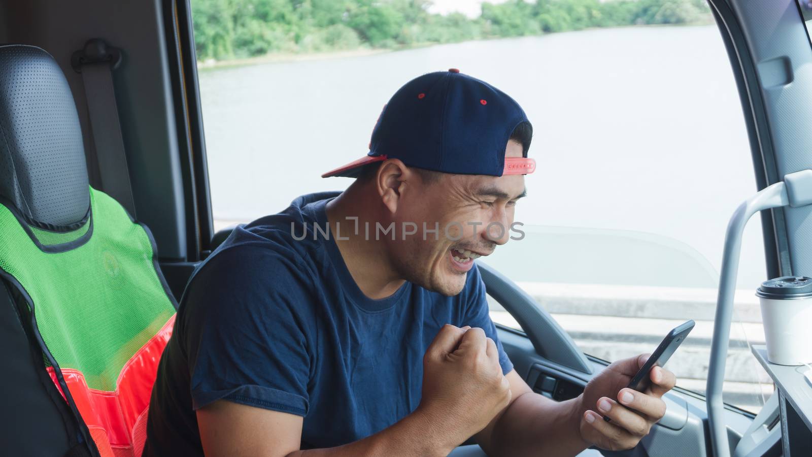 Asian truck drivers are using their smartphones to communicate happily in the car. Fast, fast wireless communication with high-speed internet.