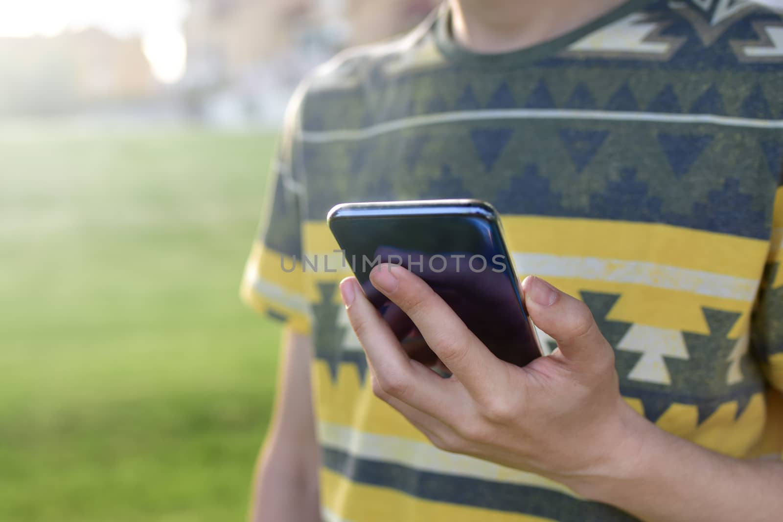 Close up view of male hands typing text message outdoors