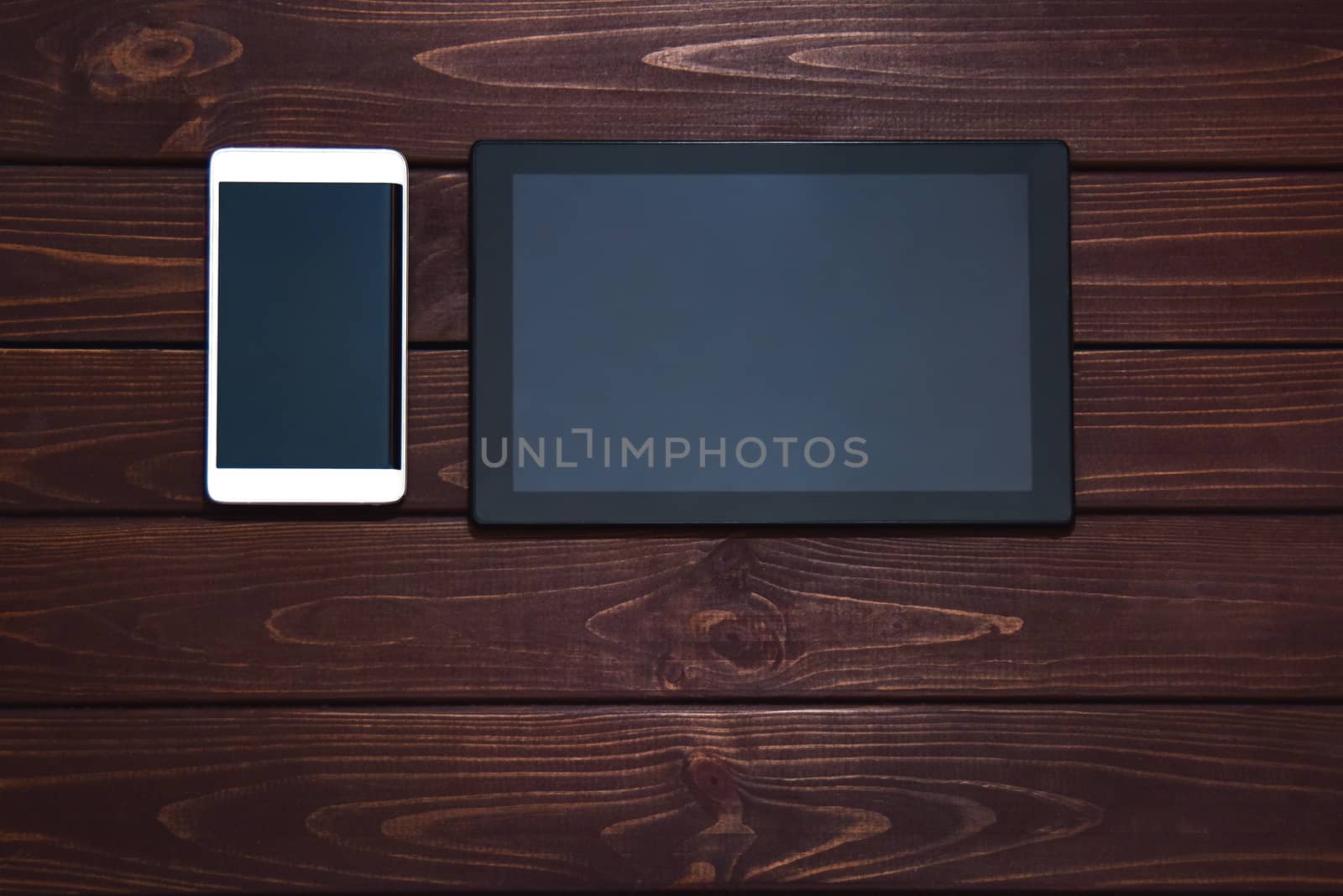 modern smart phone and tablet pc on wooden table. technology concept. free copyspace