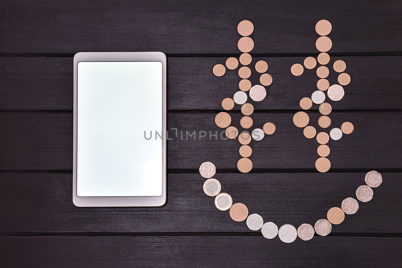 Financial success concept. Smartphone and Coins Formed A Smiley Face emoji on the table. Lucky day. success business. free copyspace