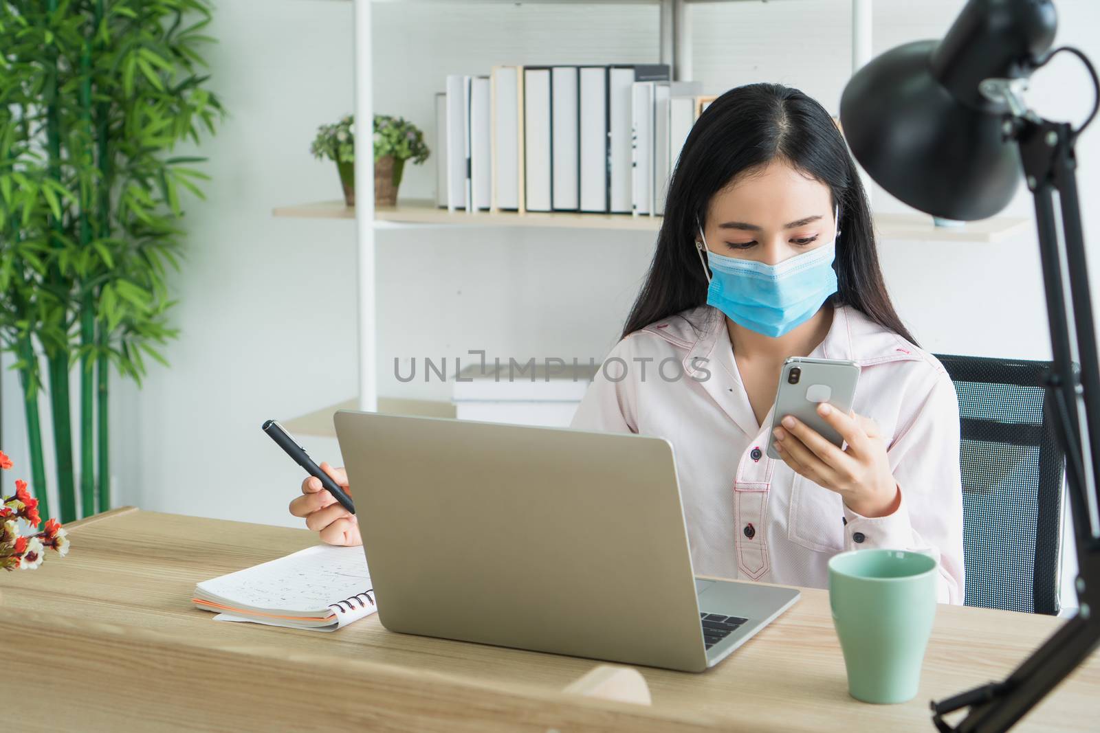 Asian business women wear medical masks, work from home Is a distance from society To prevent the spread of Corona virus