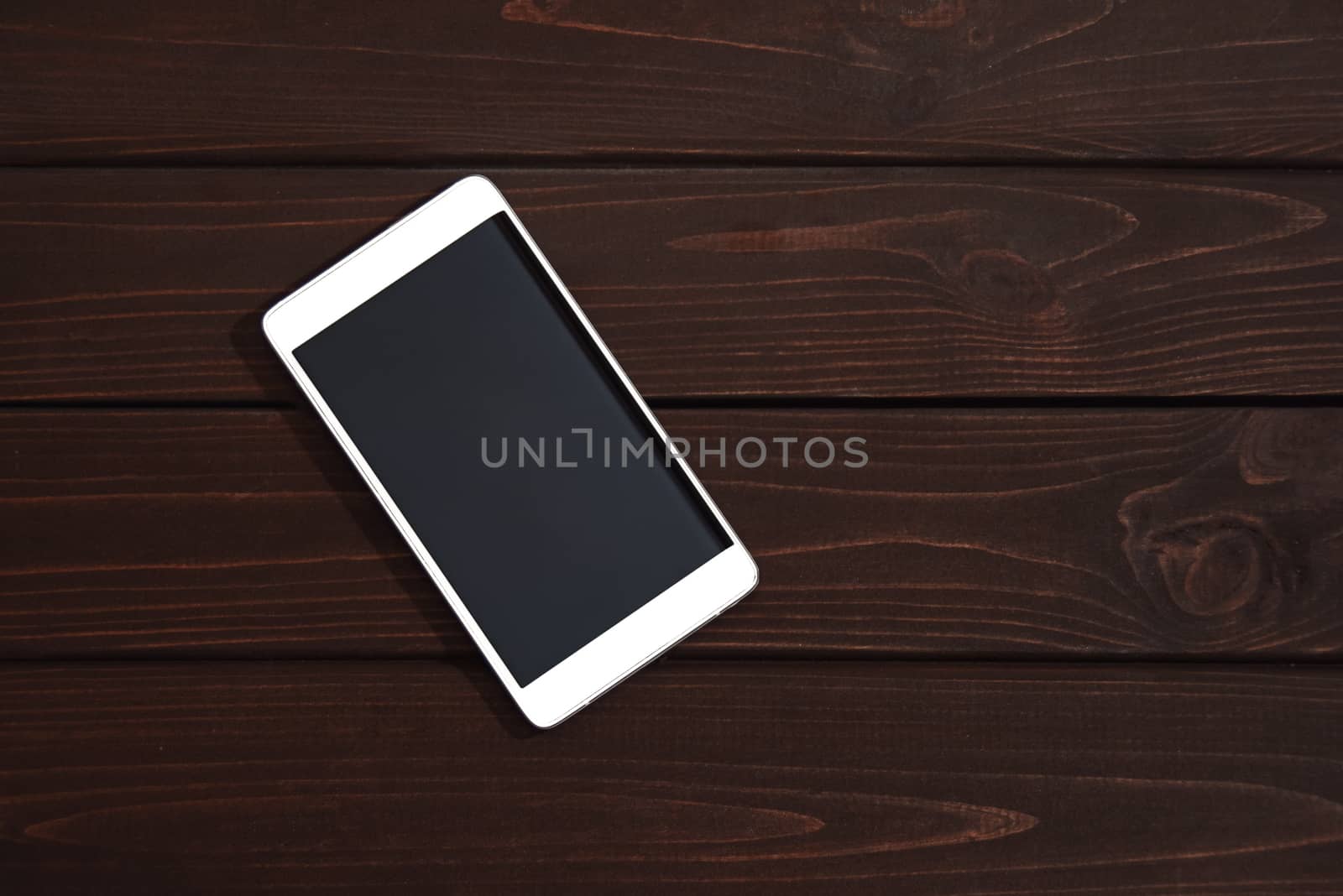 Mobile phone on wooden table background. Smartphone on wood old plank vintage texture background. top view