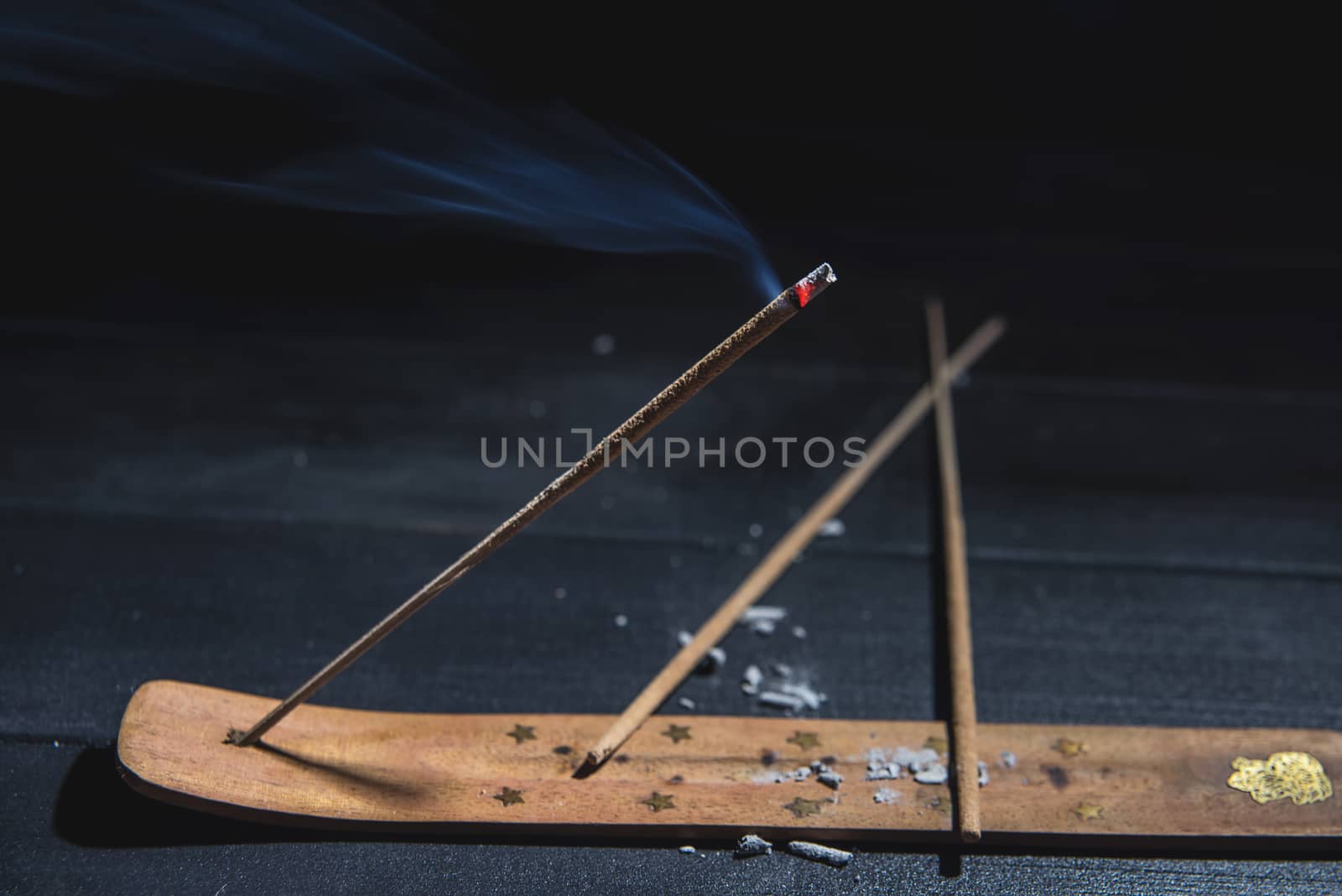 smoldering aromatic stick in the dark, a lot of smoke