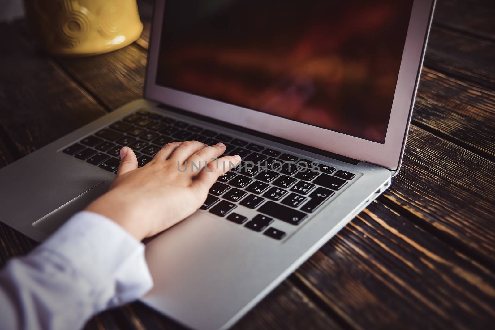 Person working on a modern laptop on a wooden bench