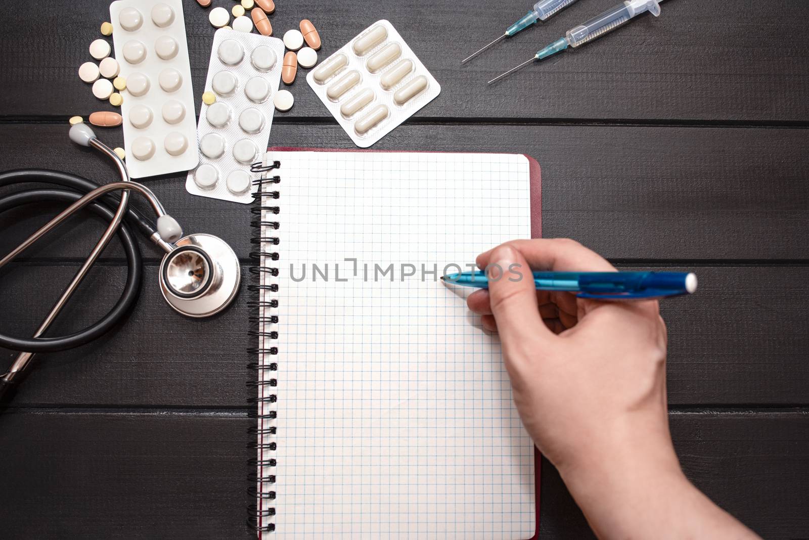 Medication prescription with pills and stethoscope lies on wooden table. Tablet or drug. Medicine and healthy concept. Copy space for text. Close-up. Indoors.