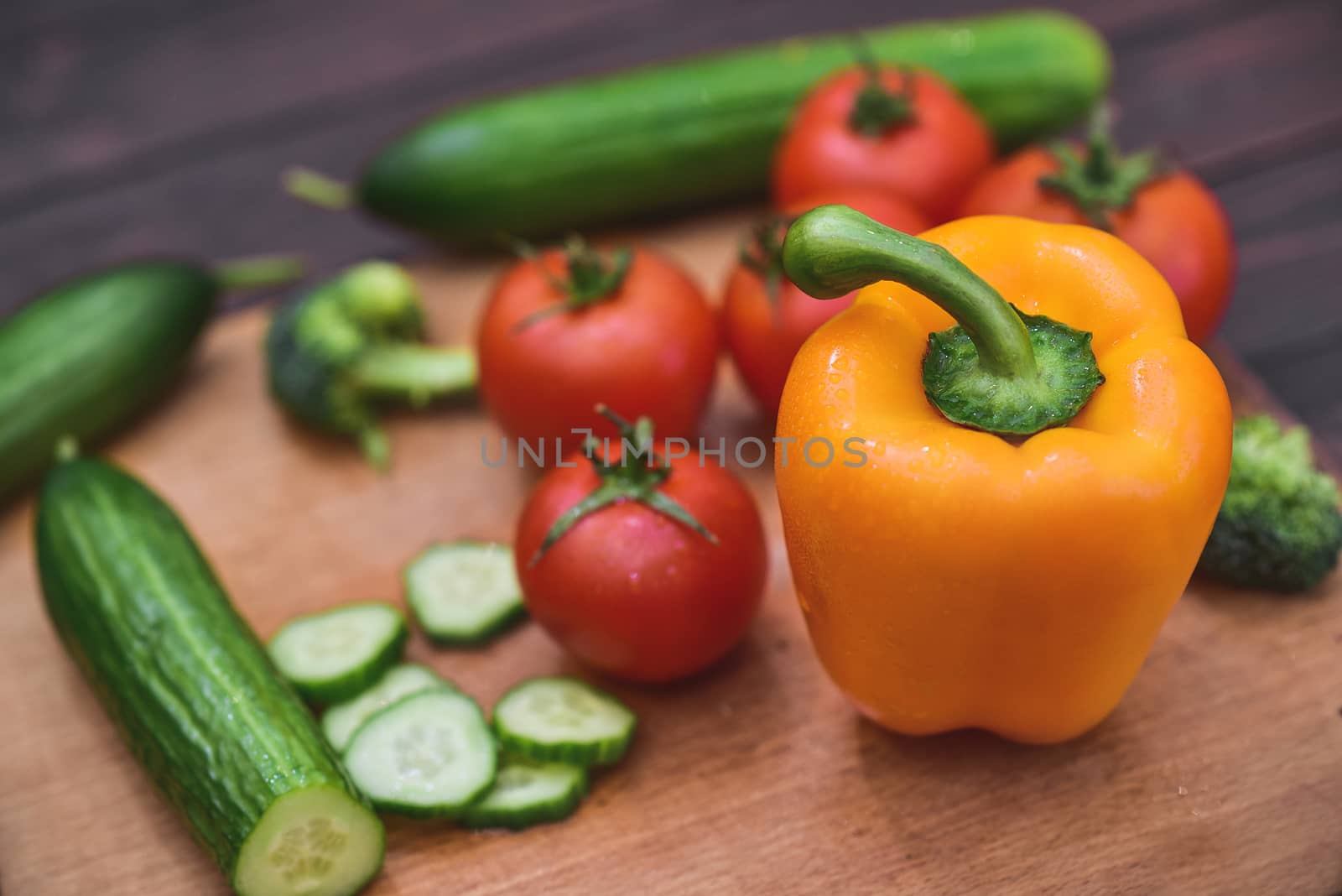 Nature Gifts. Benefits for the body. Fresh sliced vegetables lie on a wooden table. Tomatoes .cucumbers. broccoli. pepper. carrots.