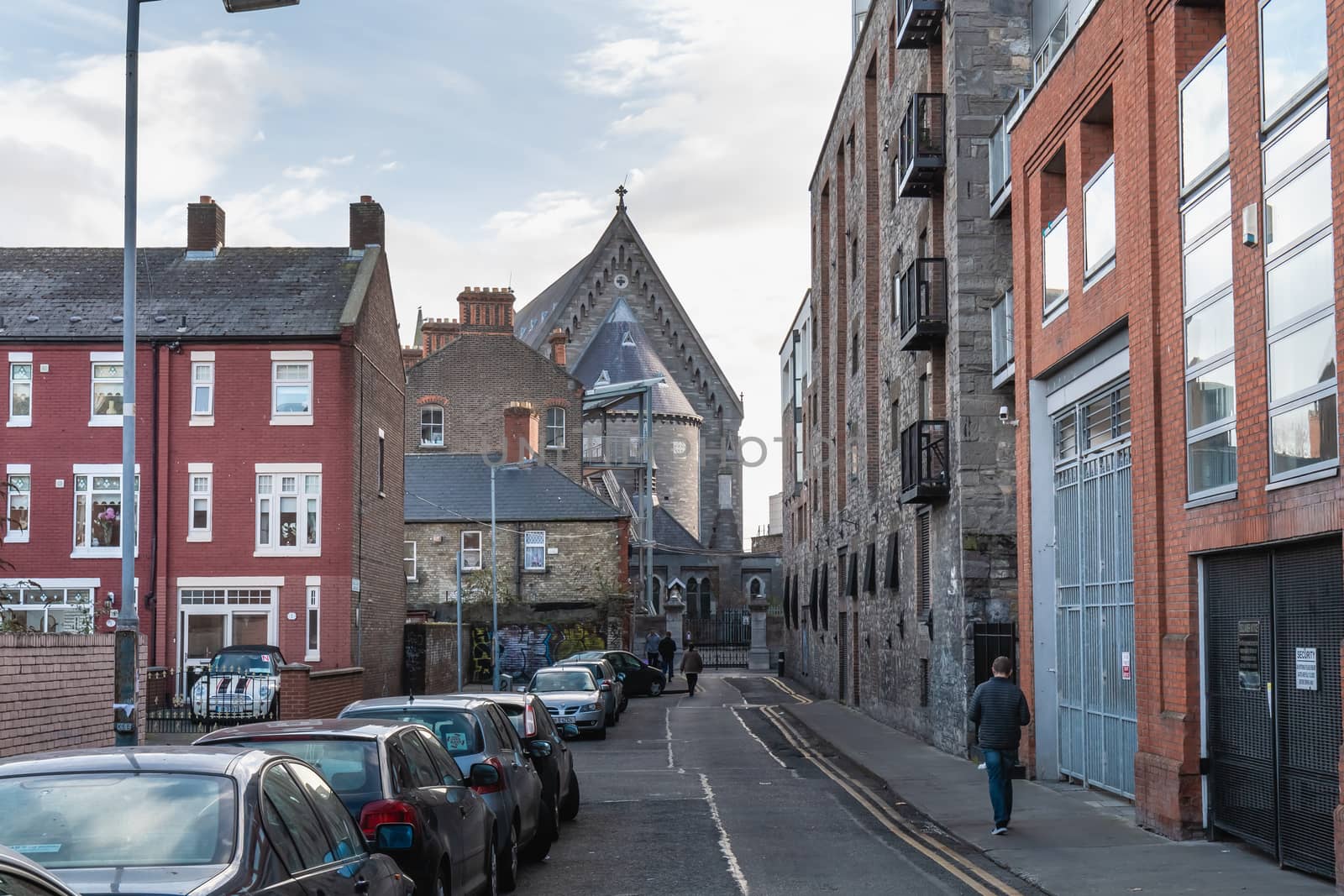 Dublin, Ireland - February 16, 2019: people walking down a small street with typical architecture of small downtown areas on a winter day